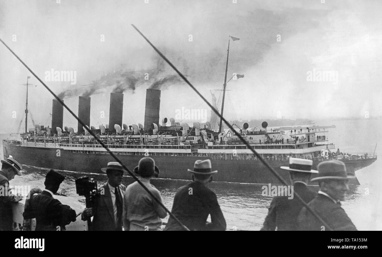 Der cunard Ocean Liner 'Mauretania' führt an der Freiheitsstatue. Das Bild wurde von der White Star Line Schiff "Homeric" übernommen. Stockfoto