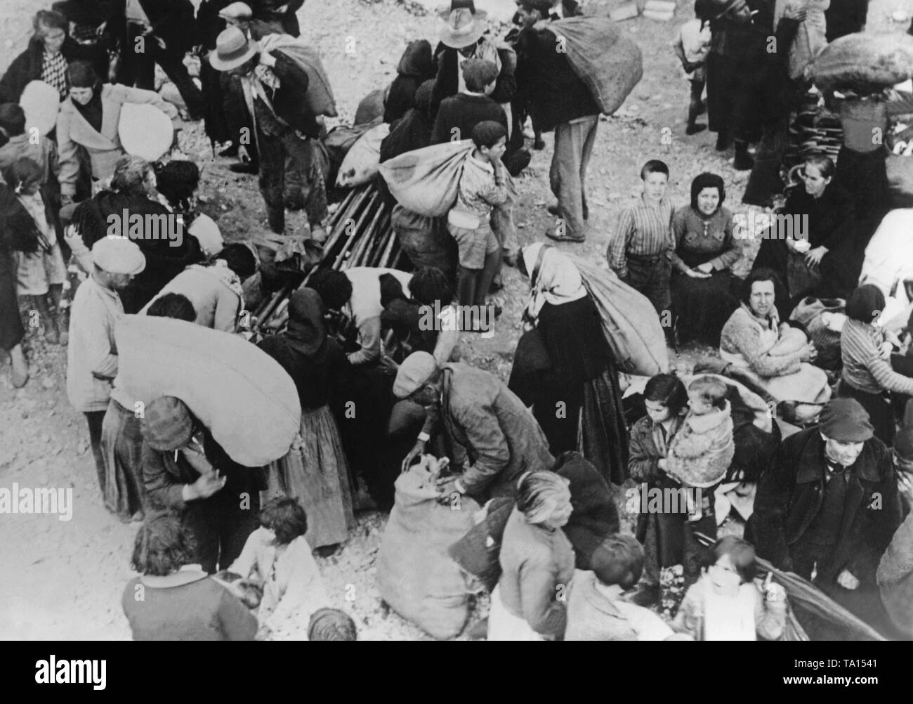 Foto der Landwirte auf der Flucht vor dem Krieg und Repression in der Provinz Valencia 1937. Menschen tragen ihre Besitztümer in Säcken auf dem Rücken. Stockfoto