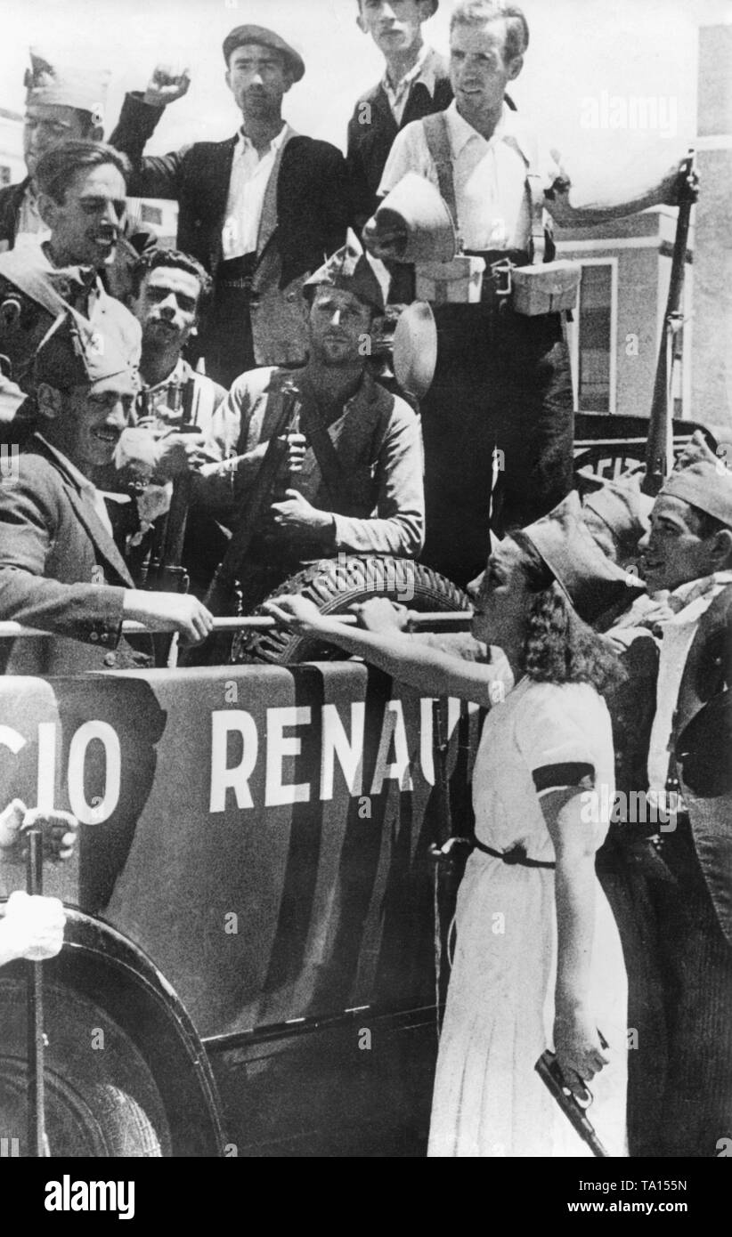 Foto von einer Gruppe von freiwilligen Milizsoldaten loyal gegenüber der Regierung in einem Renault Auto in Madrid kurz nach dem Ausbruch des Spanischen Bürgerkrieges am 29. Juli 1936. Die Kämpfer, die in der Uniform oder Zivilkleidung, Paddles und Gewehre. An der Vorderseite des Autos, eine junge Frau steht in einem weißen Kleid mit einem gorillo Hut und eine Pistole in der Hand. Die Freiwilligen sollen die republikanischen Truppen in die Kämpfe in der Sierra Guadarrama im Norden von Madrid zu unterstützen. Stockfoto