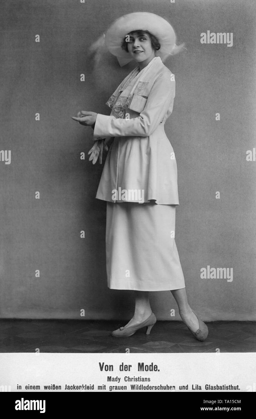 Die deutsche Schauspielerin Mady Christen trägt ein weißes Kleid mit Jacke grau Velours Leder Schuhe und einen lila Hut aus organdy. Stockfoto