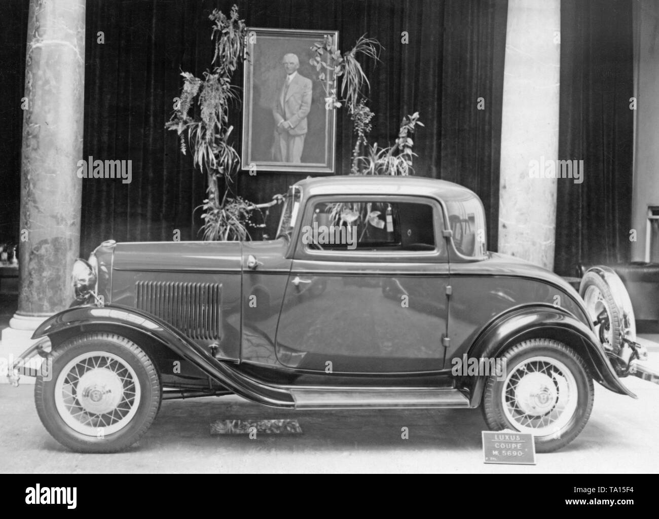 Ford Deutschland: Präsentation eines 8-Zylinder Coupé Modell 18 in Köln. Im Hintergrund ist ein Portrait von Henry Ford. Stockfoto