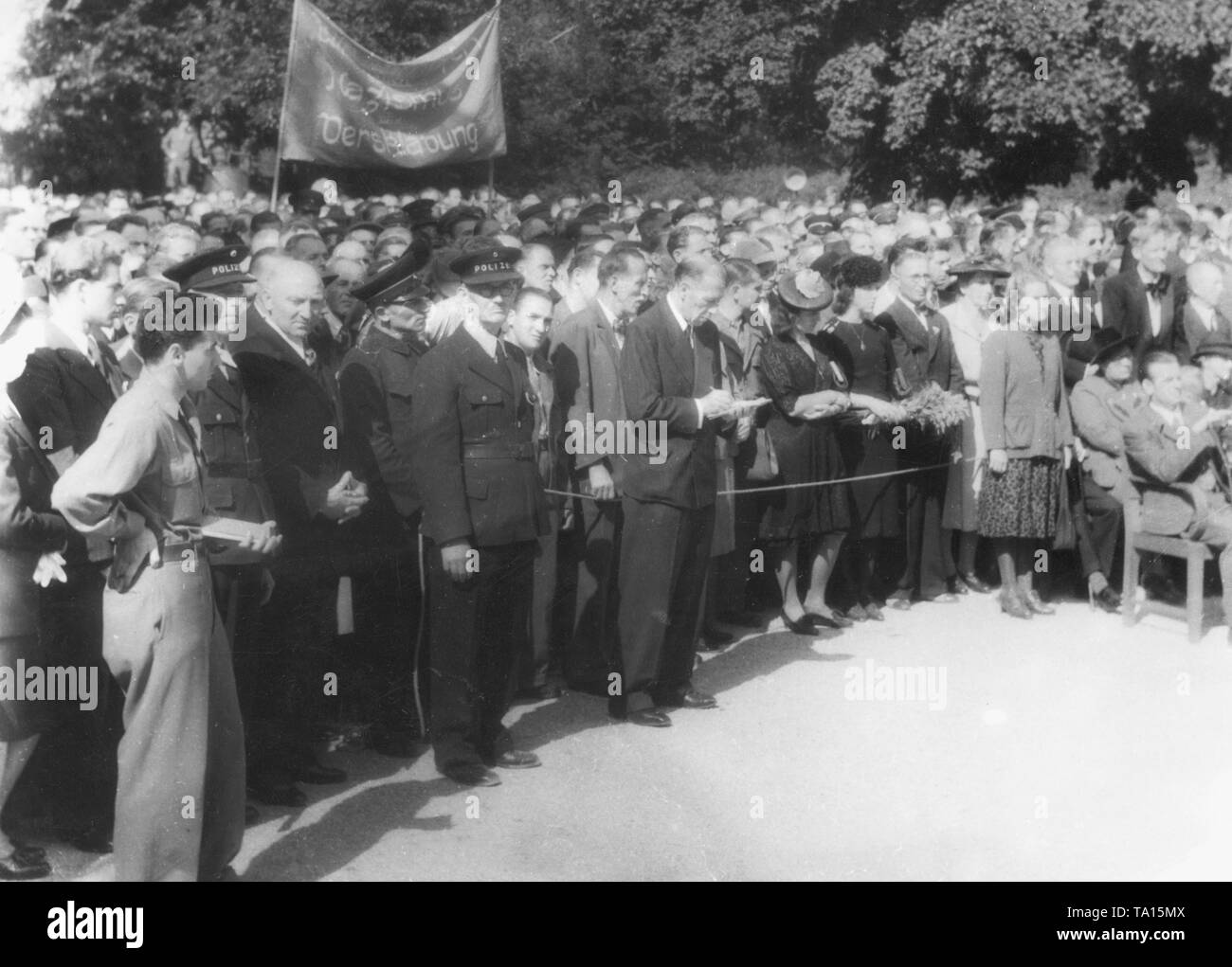 Gedenkstunde für die Opfer des KZ Dachau auf dem Münchner Ostfriedhof (Ost Friedhof). Im Hintergrund ist ein Banner lesen'... Nationalsozialismus und Versklavung". Stockfoto