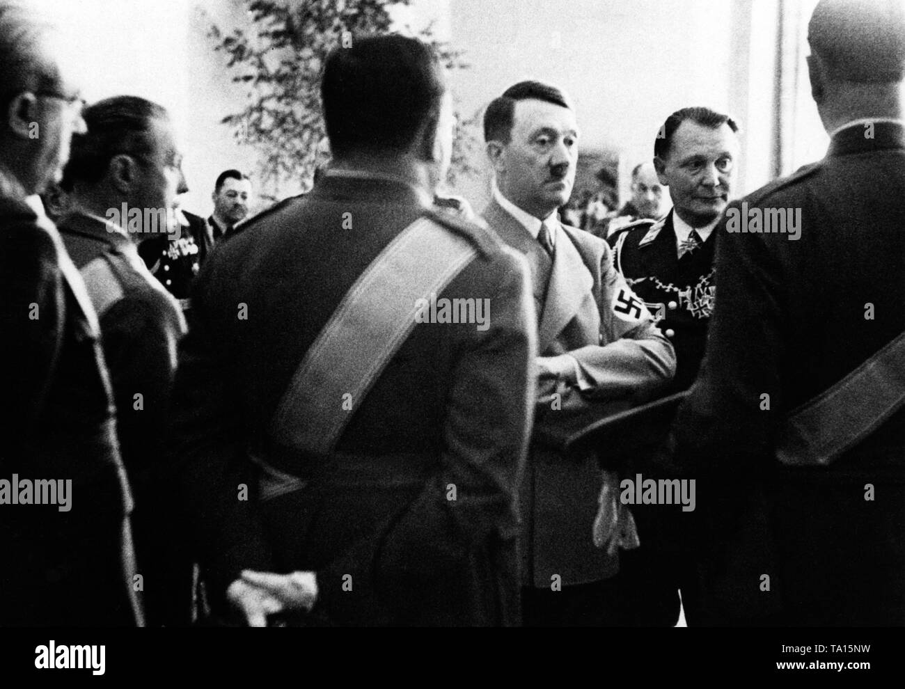 Hitler und Generalfeldmarschall Hermann Göring (rechts hinter Hitler) hören auf die Berichte von spanischen und italienischen Offizieren, die mit der Legion Condor im Spanischen Bürgerkrieg gekämpft hatte, bei einem Empfang in der Reichskanzlei. Stockfoto