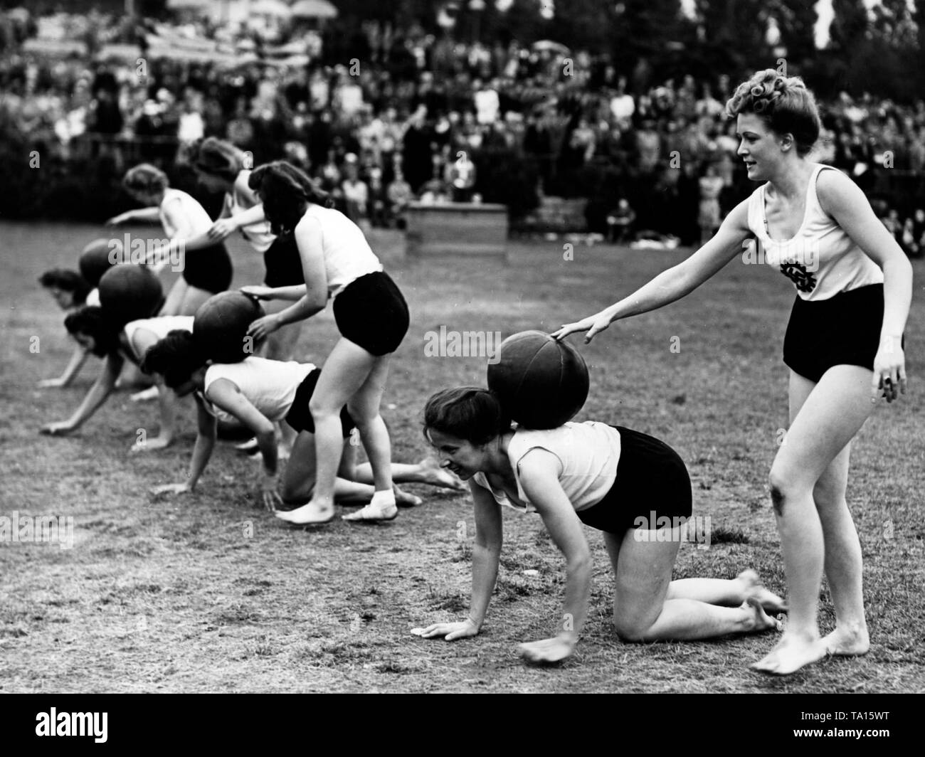 Frauen haben unterschiedliche Übungen in einem sportlichen Wettkampf der NS-Organisation "Kraft durch Freude" ('Stärke durch Freude') am Berliner Funkturm. Hier, in einem Relais Wettbewerb mit Medizin Bälle. Stockfoto