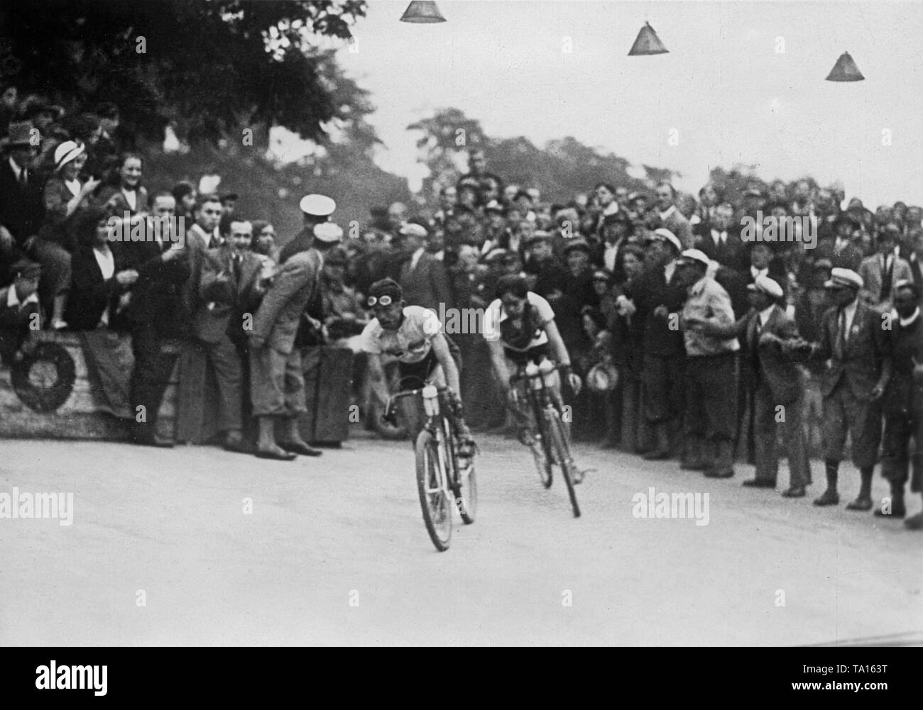 Zwei Radfahrer in einer Kurve bei der Ankunft in Warschau während der langen Distanz Radrennen Berlin-warschau. Die Straße ist voll von Zuschauern. Stockfoto