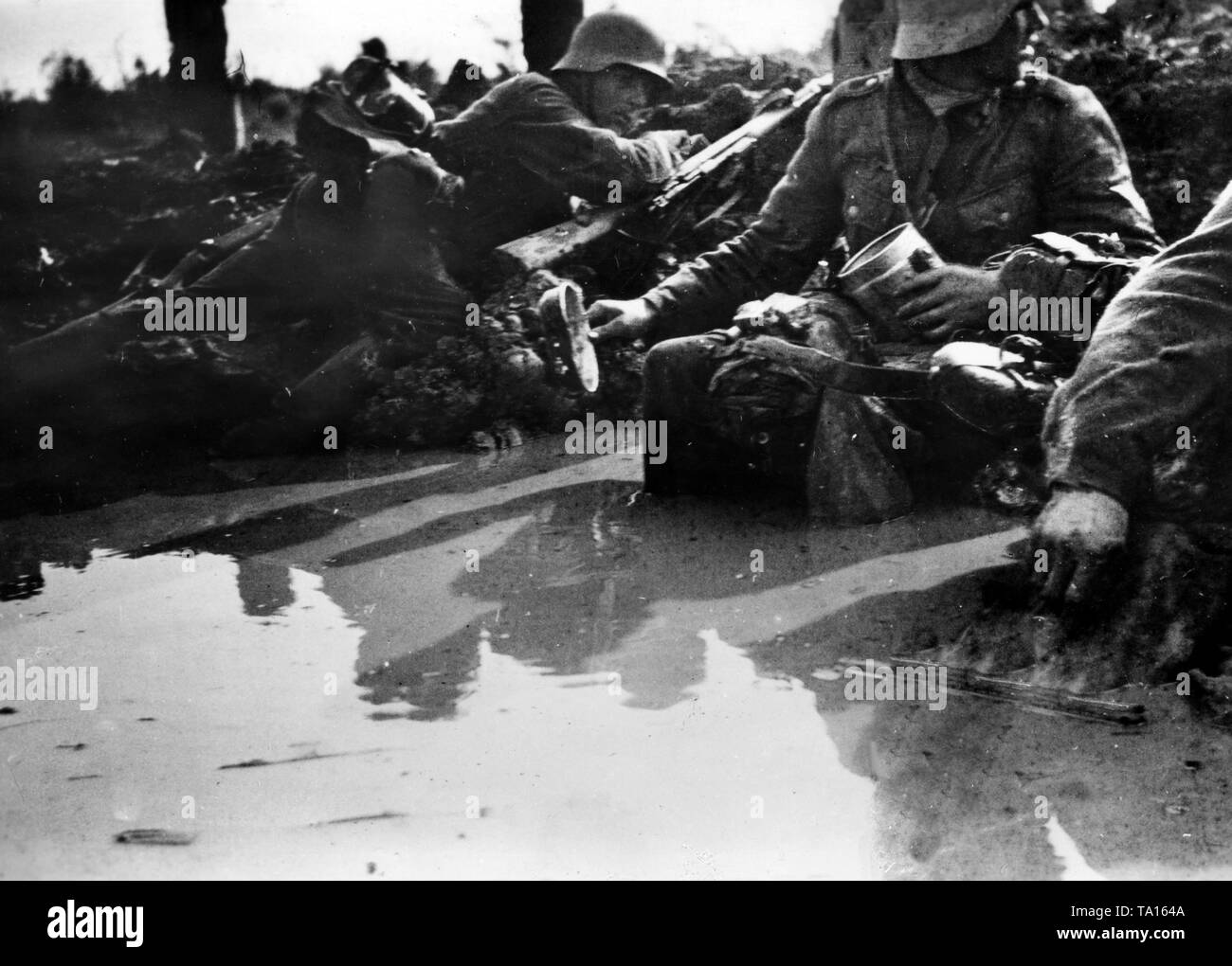 Soldaten der Wehrmacht liegen unter der Abdeckung hinter einem Sodden Damm. Aufgrund der schweren Regen und das hohe Niveau des Grundwassers, zahlreiche ehemalige foxholes und Gräben gefüllt (Foto der Propaganda Firma (PK)). Stockfoto