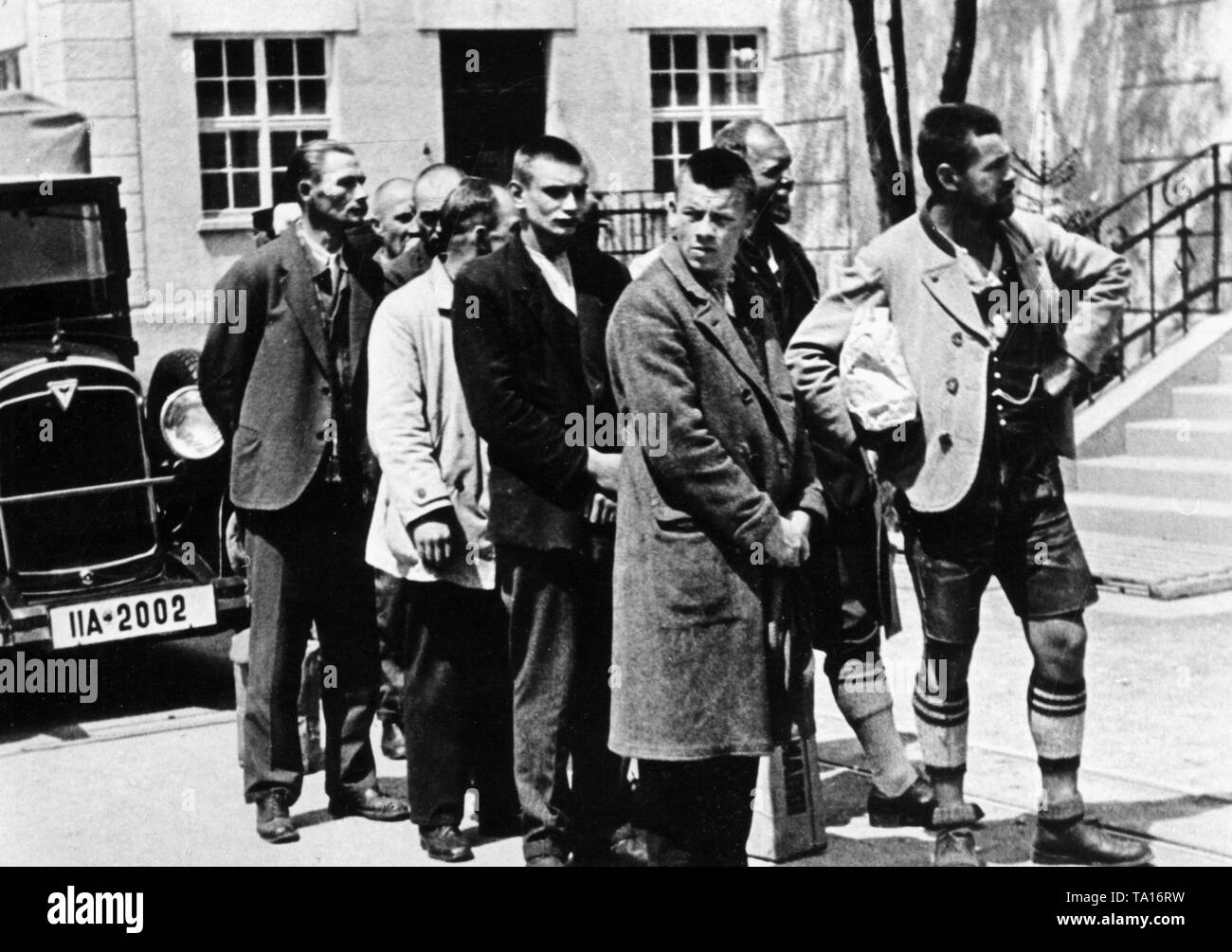 Eine Gruppe von zufällig verhaftet Leute (einige in traditionellen Kostümen) kommen an der neu errichteten Konzentrationslager Dachau im Frühjahr 1933. Stockfoto
