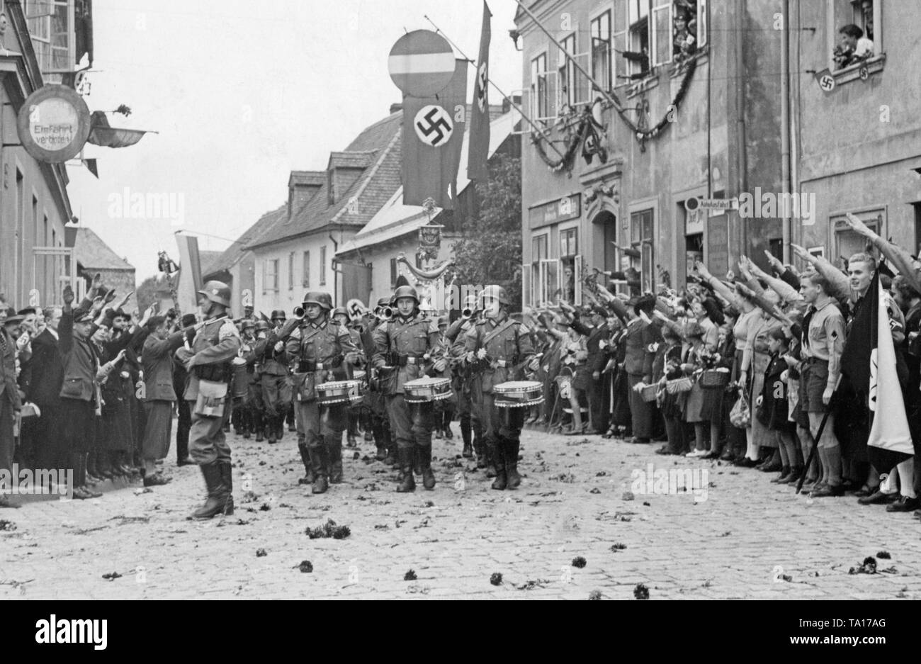 Eine Brass Band der Infanterie marschiert durch die Stadt Grottau (heute Hrádek nad Nisou) am 3. Oktober 1938. Die Bevölkerung begrüßt die Soldaten frohgemut, indem Sie ihnen den Hitlergruß. Stockfoto