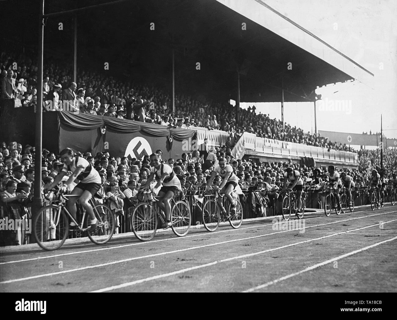 Deutsche Radrennfahrer ein Berliner Poststadion nach Beendigung der Warsaw-Berlin Rennen. Einige Leute aus dem Publikum grüßen Sie mit den Hitlergruß. Stockfoto