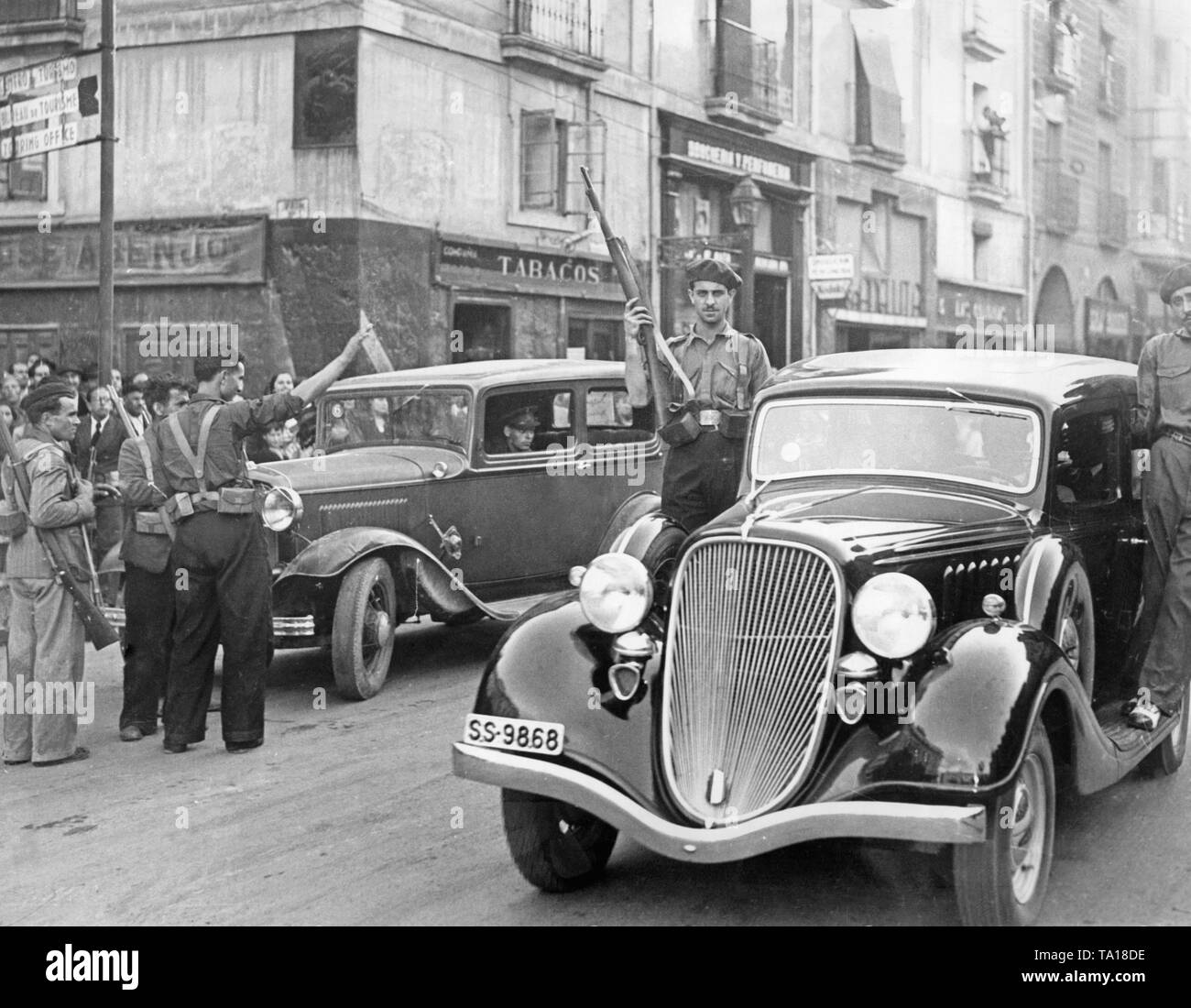 Foto von Autos in den Straßen von Madrid nach dem spanischen Volksaufstand in Madrid am 18. Juli 1936. Die Kämpfer stehen auf der trittbretter der Autos, und Sie sind mit Karabiner bewaffnet. Im Hintergrund, andere Nutzfahrzeuge. Stockfoto