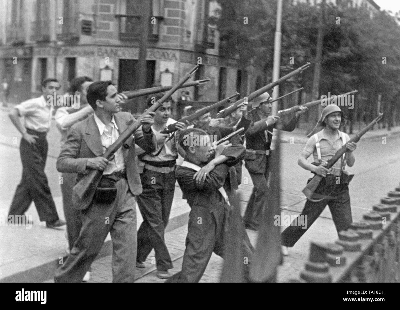 Im Sommer 1936, Kämpfer (in Zivil) der Republikanischen Volksfront sind posieren für ein französischer Fotograf in aus Körperhaltungen kurz nach Ausbruch des Spanischen Bürgerkriegs. Im Hintergrund, ein Zweig der "Banco Bizcaya' (jetzt BBVA). Foto vermutlich in Bilbao, Baskenland, Spanien. Nach dem Ausbruch des Bürgerkrieges am 17. Juni 1936, viele Städte von Spanien wurden die Szene der Strassenschlachten zwischen Republikanern und Kommunisten und Nationalisten. Stockfoto
