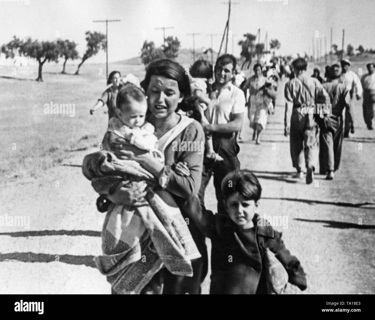 Foto von einer Straße mit fliehenden Zivilisten in der Nähe von Madrid im Herbst 1936. Die Menschen nicht Gepäck haben und ihre Kinder in die Arme. General Francisco Franco hatte versucht, Madrid mit seinen Truppen seit Oktober 1936 zu erobern. Am 8. November, General Emilio Mola angegriffen Madrid direkt mit seinen Truppen. Stockfoto