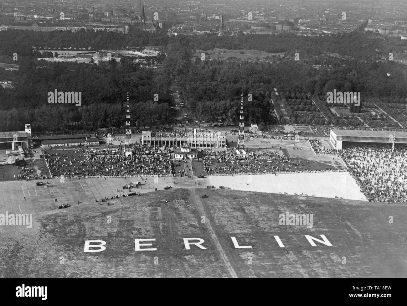 Blick auf die Einrichtungen der Flughafen Berlin-Tempelhof mit der Aufschrift Berlin. Vor der Halle ist ein gyrocopter. Stockfoto