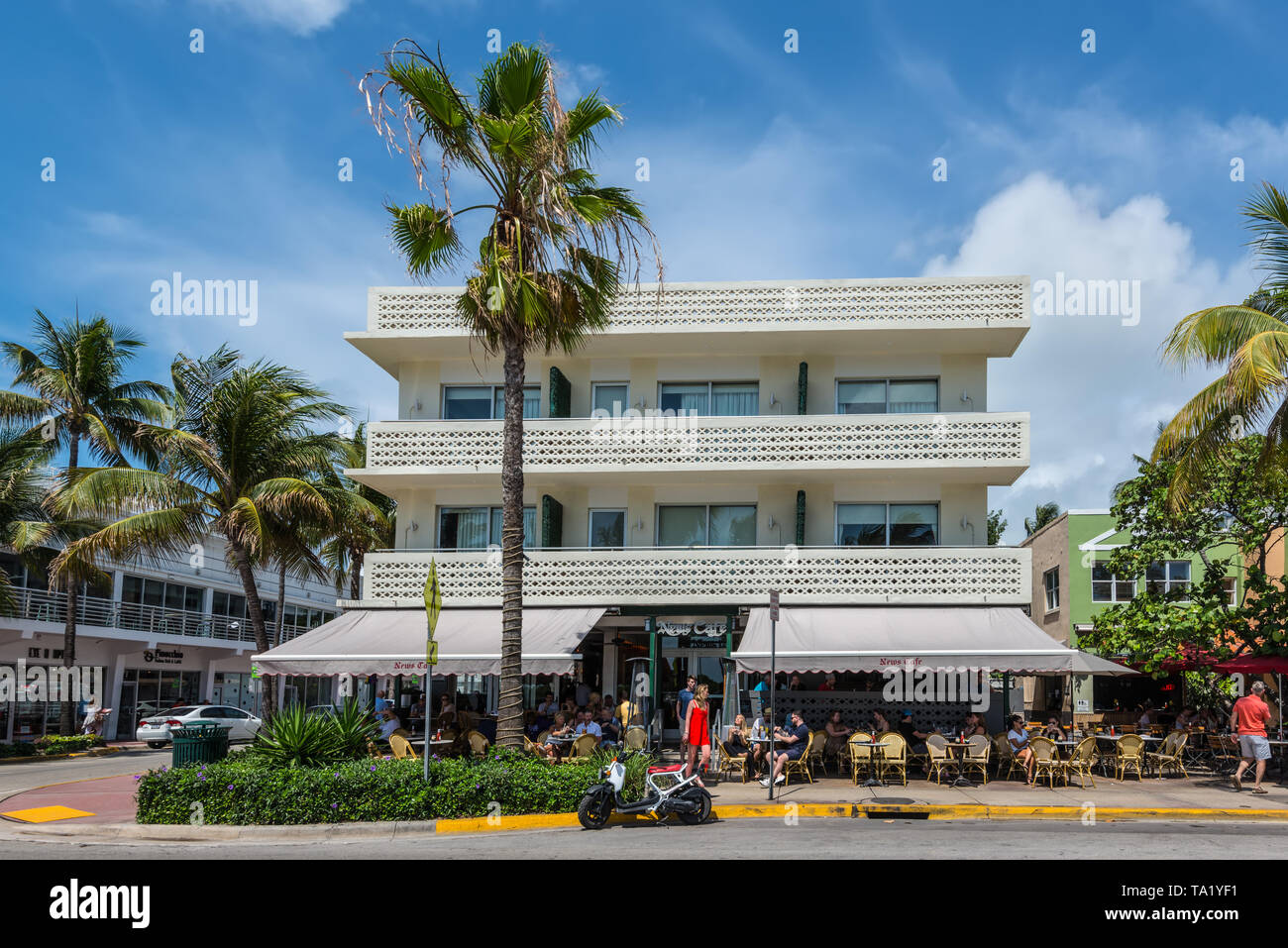 Miami, FL, USA - 19. April 2019: News Cafe im historischen Art déco-Viertel von Miami South Beach mit Hotels, Cafes und Restaurants auf dem Ozean Dri Stockfoto Miami, FL, USA - 19. April 2019: News Cafe im historischen Art déco-Viertel von Miami South Beach mit Hotels, Cafes und Restaurants auf dem Ozean Dri Stockfoto