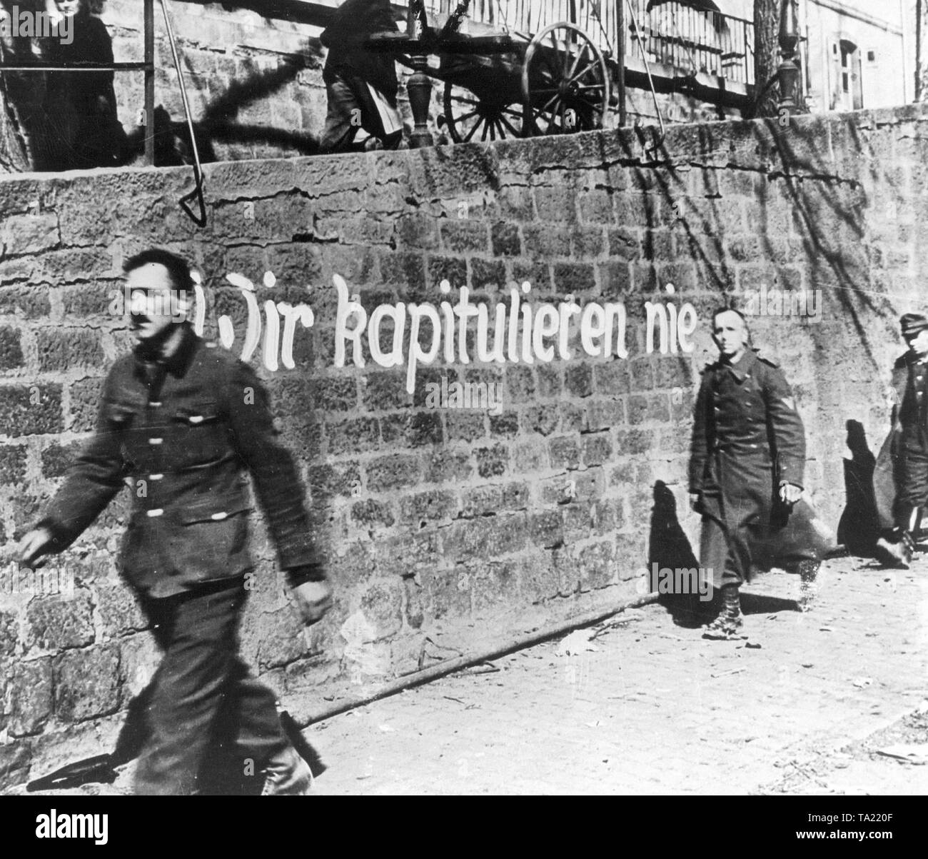 Eine Mauer in Deutschland mit dem Slogan "Wir werden nie gegen Ende des Zweiten Weltkrieges, April 1945 (s/w Foto Übergabe") Stockfoto