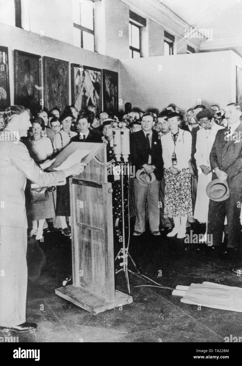 Aufgezeichnet: 19. Juli 1937. Senator der Bildenden Künste an der Reich Kammer der Kultur Adolf Ziegler bei der Eröffnung der Ausstellung "Entartete Kunst" in München spricht. Im Hintergrund Bilder von Otto Mueller Stockfoto