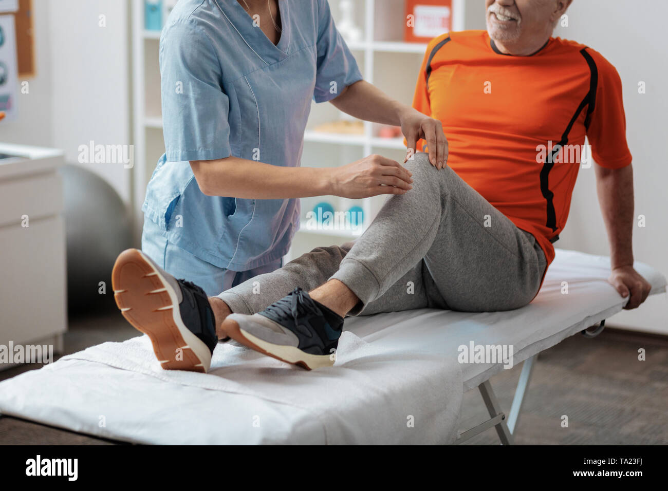 Nahaufnahme von Krankenschwestern Hände massiert das Knie Stockfoto