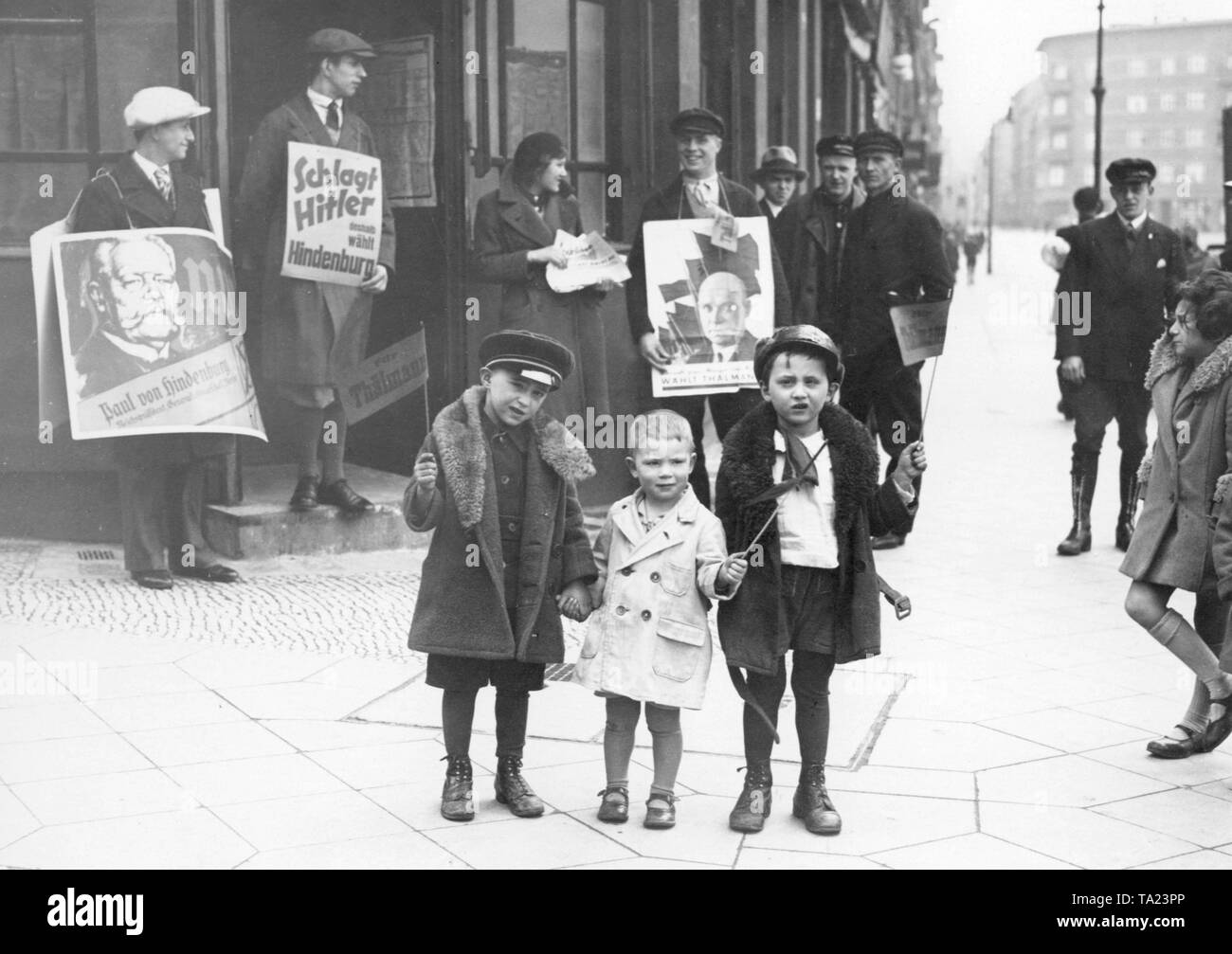 Die KPD wirbt mit Kindern für ihren Kandidaten Ernst Thälmann vor dem Wahllokal in der Berliner Buelowplatz, links im Bild sind zwei Wahlkampf für Präsident Paul von Hindenburg. Stockfoto
