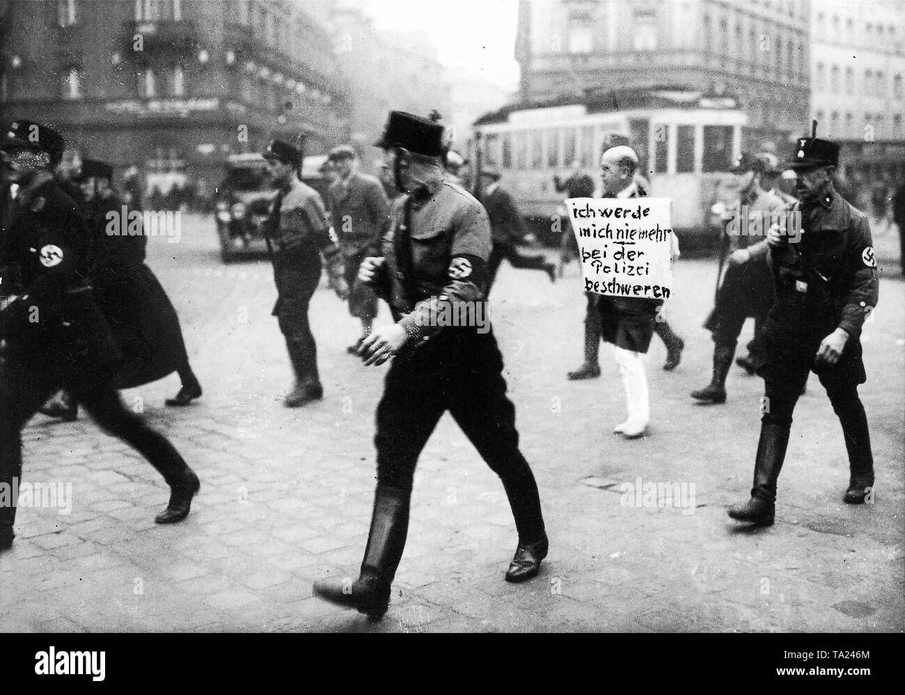 Dieses Foto von März 1933 aus München zeigt deutlich die fehlende Rechte jüdischer Bürger und der brutalen Zugriff der SS und SA nach der Machtübernahme durch die Nationalsozialisten im Januar 1933. Der Münchner jüdischen Rechtsanwalt Dr. Michael Siegel, der versuchte, in der Polizei gegen die Übergriffe der SA zu beschweren war durch die Innenstadt von München mit abgeschnittenen Hosen, barfuß, mit einem Schild um den Hals: "Ich nie beschweren bei der Polizei". Stockfoto