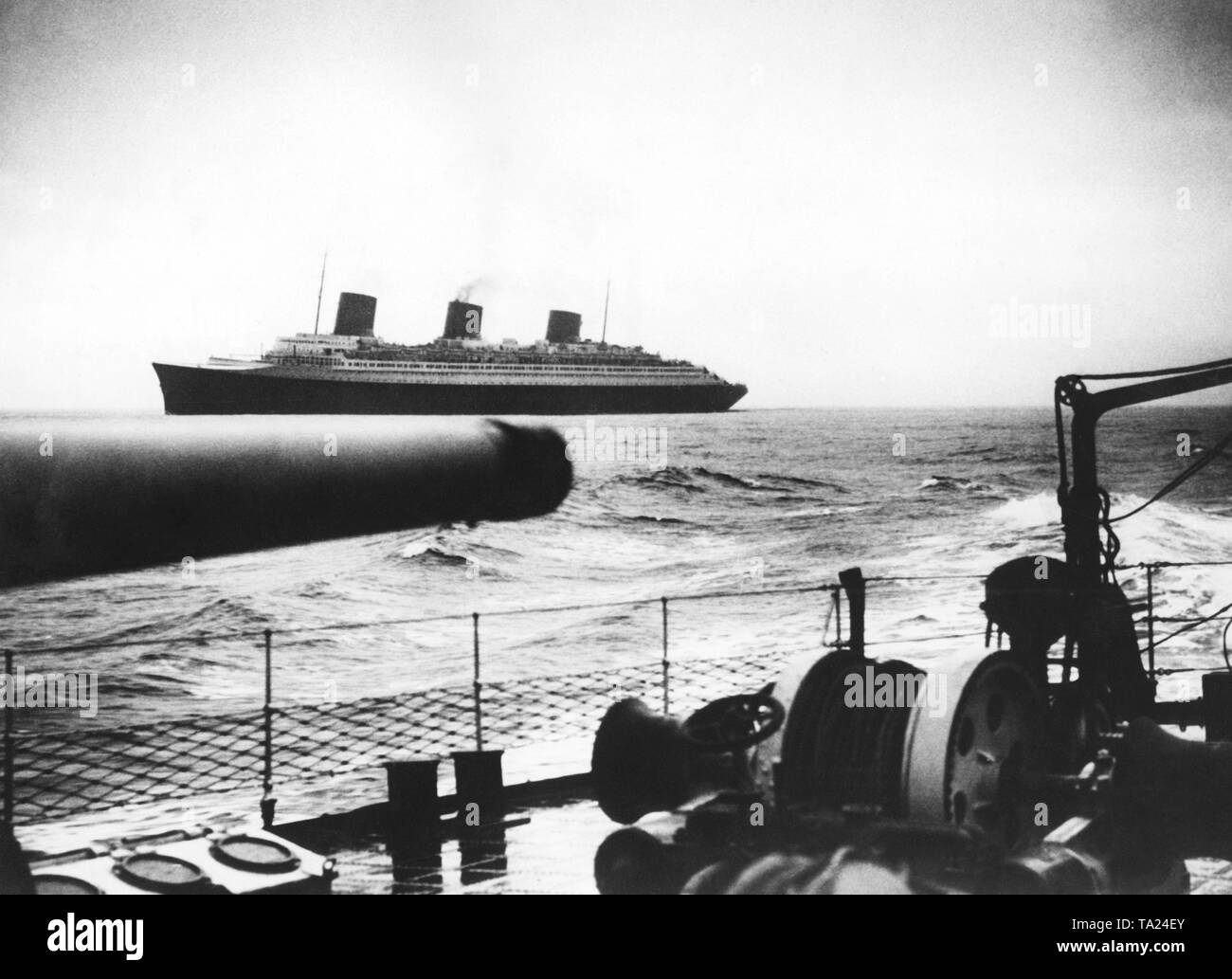 Ein Schlachtschiff erfüllt die französischen Ozean Liner "Normandie" auf See. Stockfoto