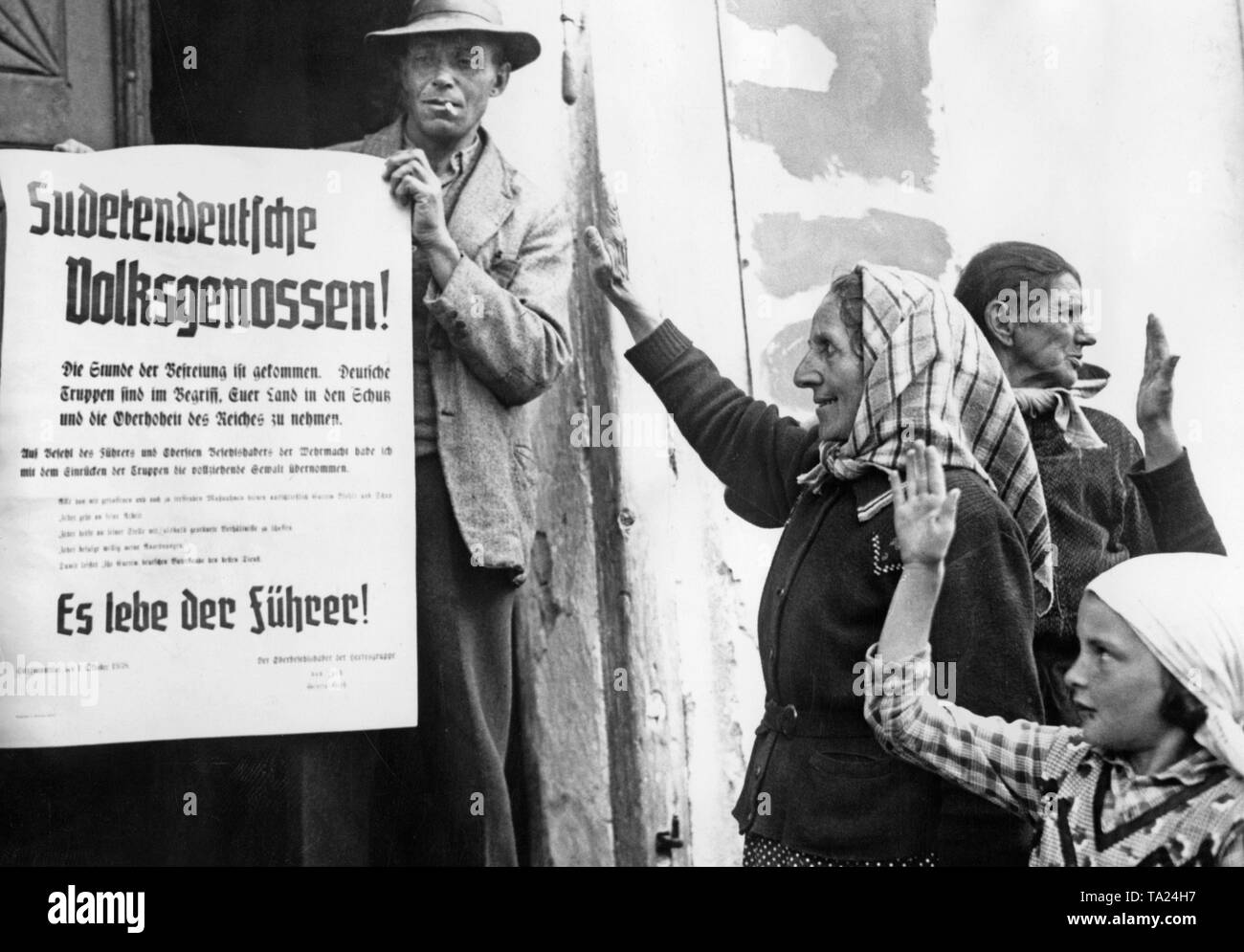 Zu der Aussage von Hitler die Annexion des Sudetenlandes an das Deutsche Reich. Nach dem Münchner Abkommen, das Sudetenland an das Deutsche Reich gehört. Frauen und Kinder zeigen den Hitlergruß. Stockfoto