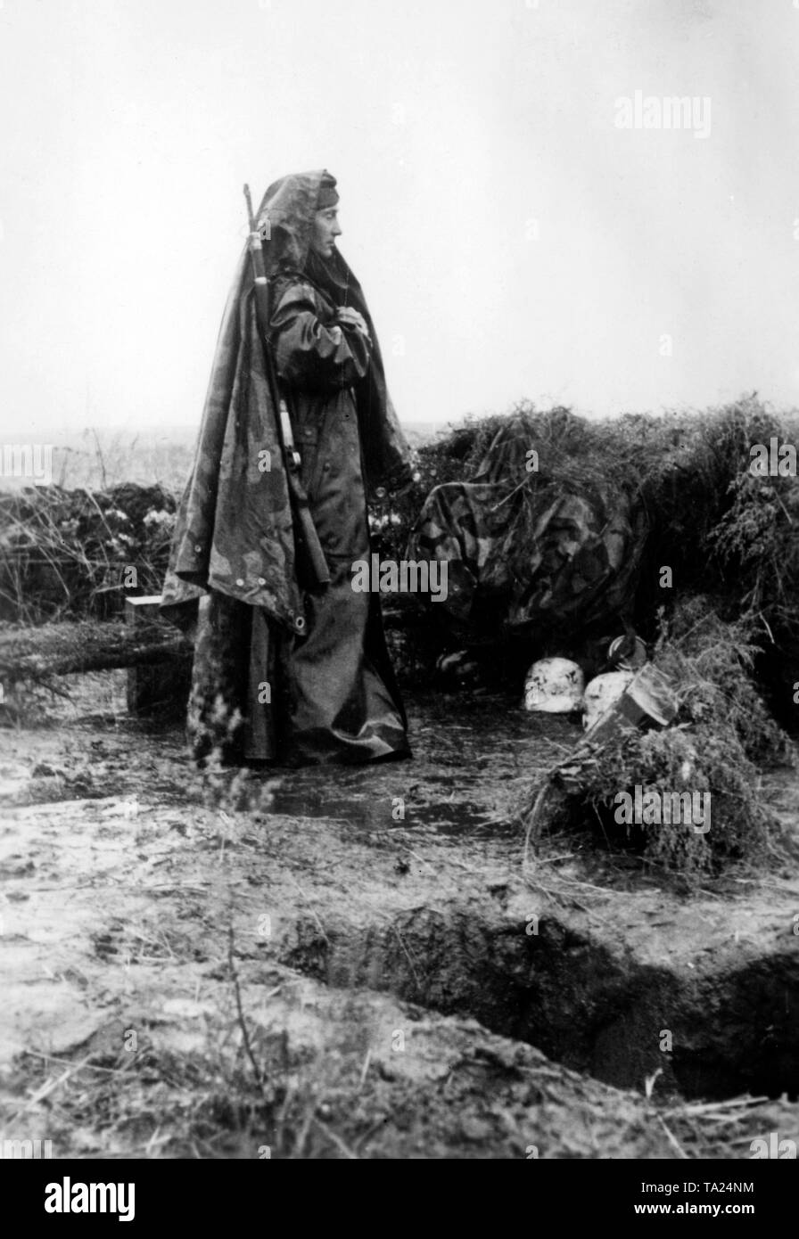 Ein Soldat verkleidet sich mit einer Plane, während er Wache auf seinem Posten. Lang anhaltende Regenfälle haben den Schnee in die Feder erneuert. Foto der Propaganda Firma (PK): kriegsberichterstatter Przibilla. Stockfoto