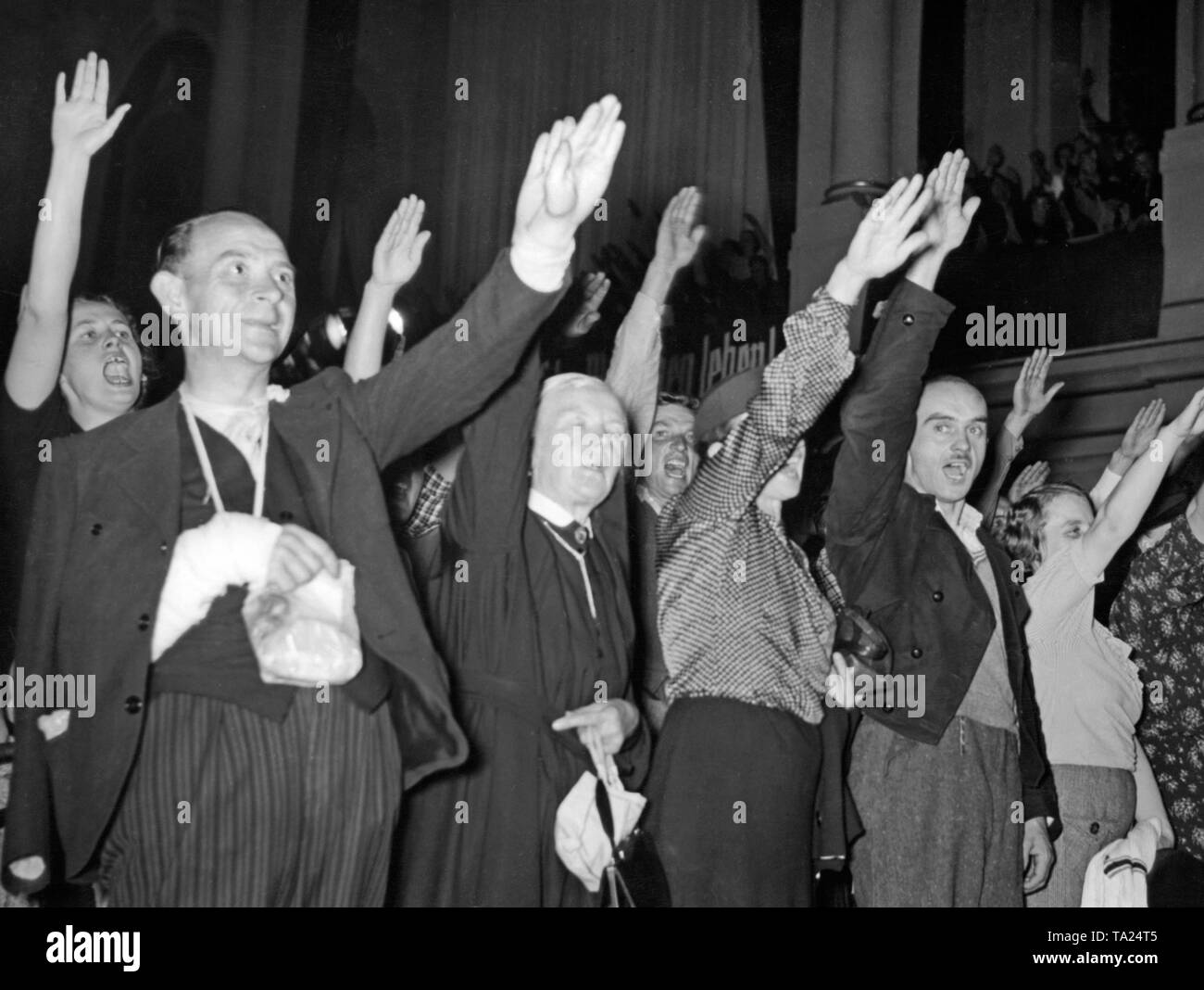 Flüchtlinge aus dem Sudetenland sang die "Deutsche Lieder" (Deutsche Lieder') bei einer Kundgebung in der Staedtischer Austellungspalast (Kommunale Ausstellung Palast) in Dresden am 19. Oktober 1938. Stockfoto