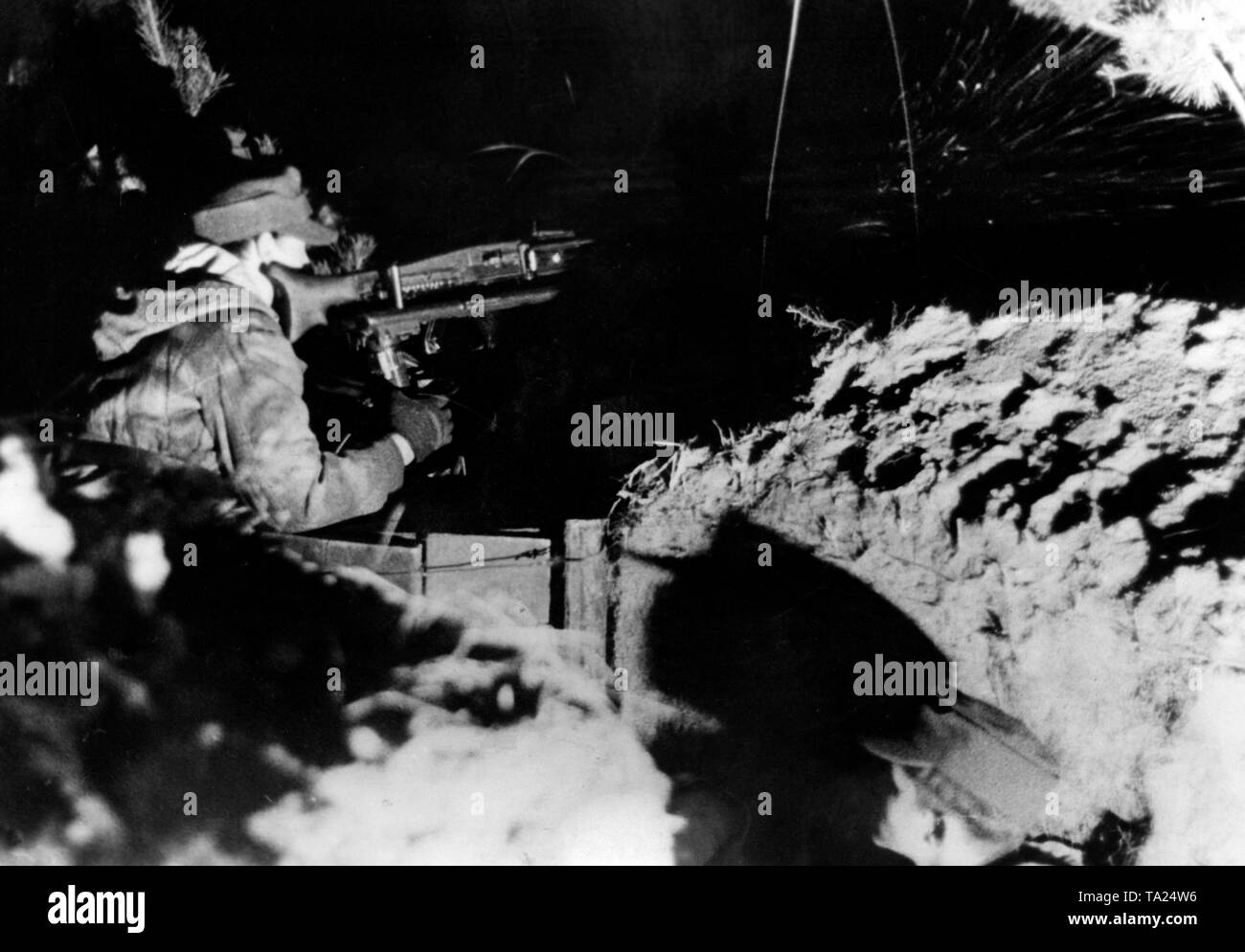 Ein Soldat steht Wache auf einem MG 42 auf eine Pistole Schlitten in eine Position in der Prinsk Sümpfe montiert. Er trägt eine Tarnung uniform. Foto: kriegsberichterstatter Etzold Stockfoto