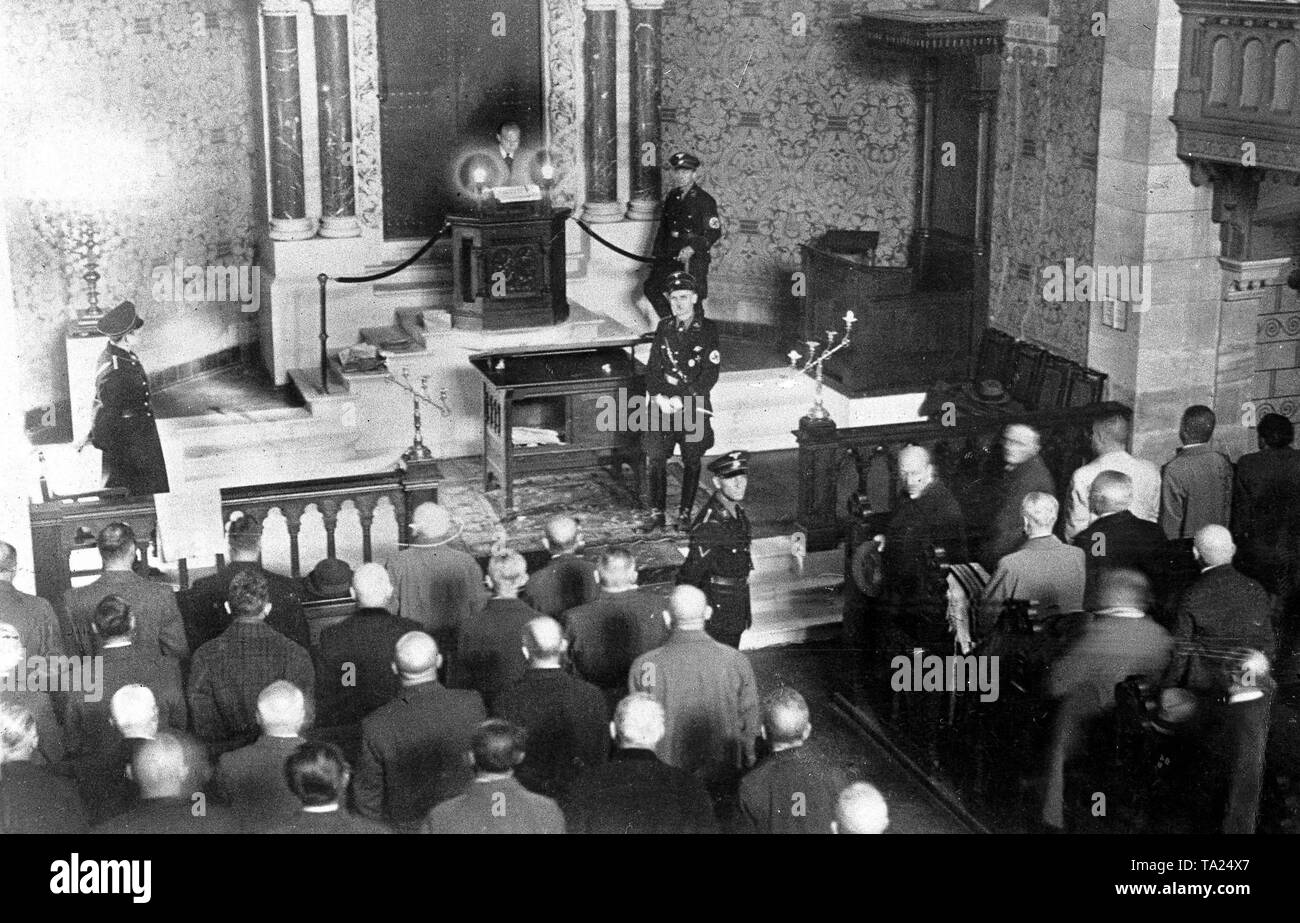 In Baden-Baden 60 deutsche Juden wurden in der Synagoge der Kristallnacht und Dr. Flehinger, flankiert durch SS-Männer zusammengetrieben, gezwungen wurde, von Hitlers "Mein Kampf" auf der Tribüne, von der aus der Tora gelesen wird. Danach hatten sie das Horst-Wessel-Lied zu singen dann die synygoge wurde in Brand gesetzt. 40 Männer im Konzentrationslager Dachau angekommen. Stockfoto