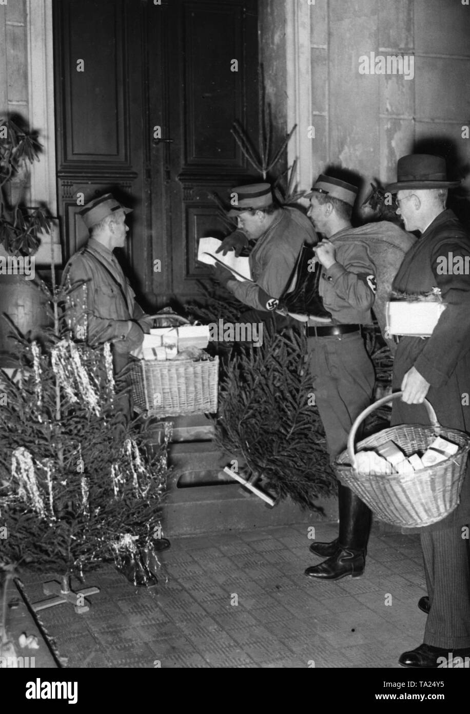 Männer der NS-Volkswohlfahrt verteilen "Pfundspende" (Waren gespendet) und Weihnachtsbäume an bedürftige Bevölkerung für das winterhilfswerk zur Weihnachtszeit. Stockfoto