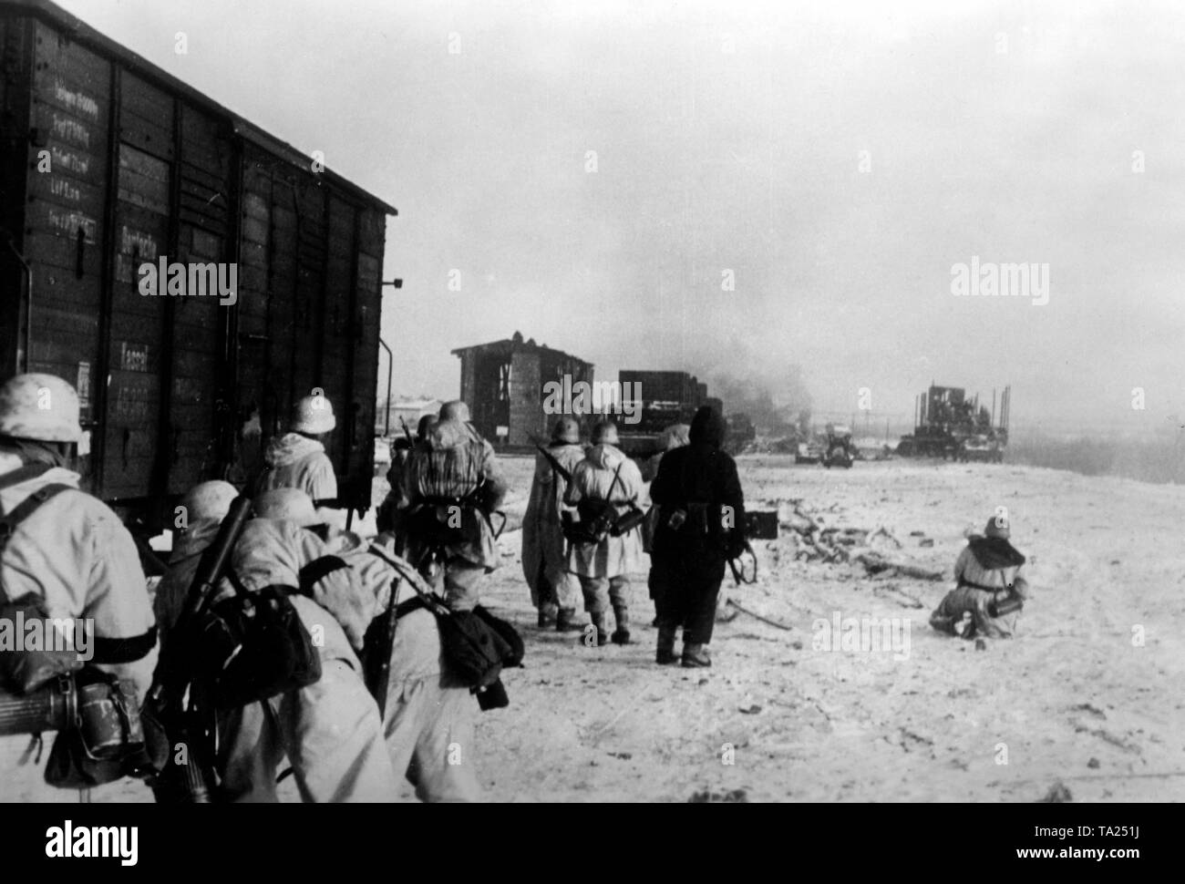 In der zweiten Schlacht von Ladoga, Es gab Kämpfe für ein güterbahnhof (vermutlich aus Pogoste). Deutsche Soldaten im Winter camouflage beachten Sie die feindliche Stellungen neben einem Güterwagen. Foto der Propaganda Firma (PK): kriegsberichterstatter Slapak. Stockfoto