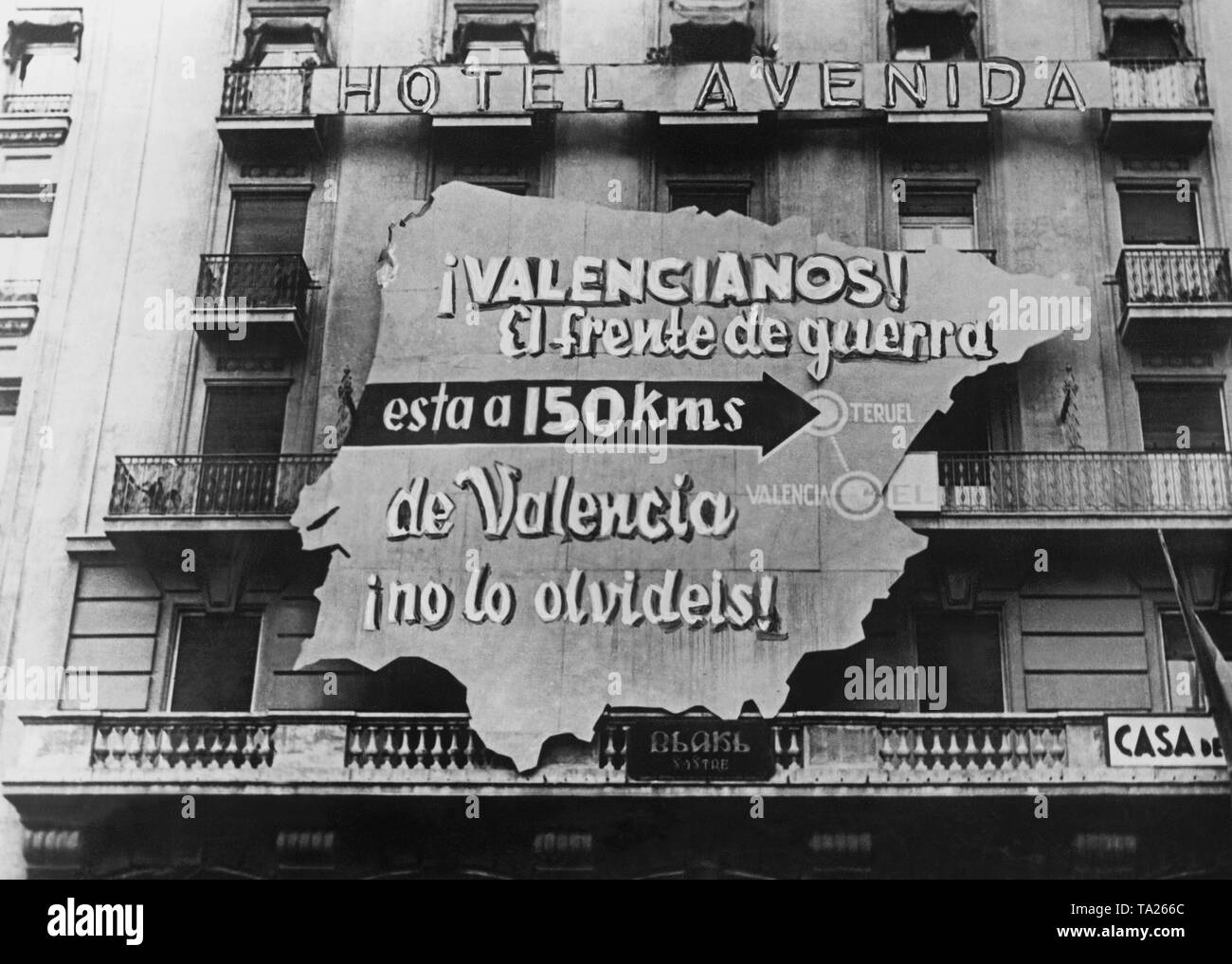 Foto einer Propaganda Plakat der republikanischen Regierung in Form einer Karte von Spanien auf der Fassade des Hotel Avenida in Valencia. Inschrift: Valencia. Die Schlacht ist nur 150 km von Valencia entfernt. Tun sie es nicht vergessen! Teruel gekennzeichnet ist. Stockfoto