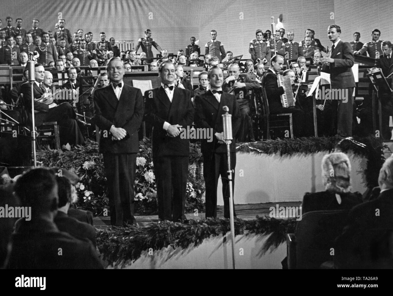 Die drei Solisten in der vorderen Reihe sind (von links): Hans Brausewetter, Josef Sieber und Heinz Ruehmann. Dies ist eine Szene aus dem Propagandafilm "Wunschkonzert" von Eduard Borsody, in der sie singt das Lied 'Das kann doch einen Seemann nicht Erschuettern" geleitet. Stockfoto