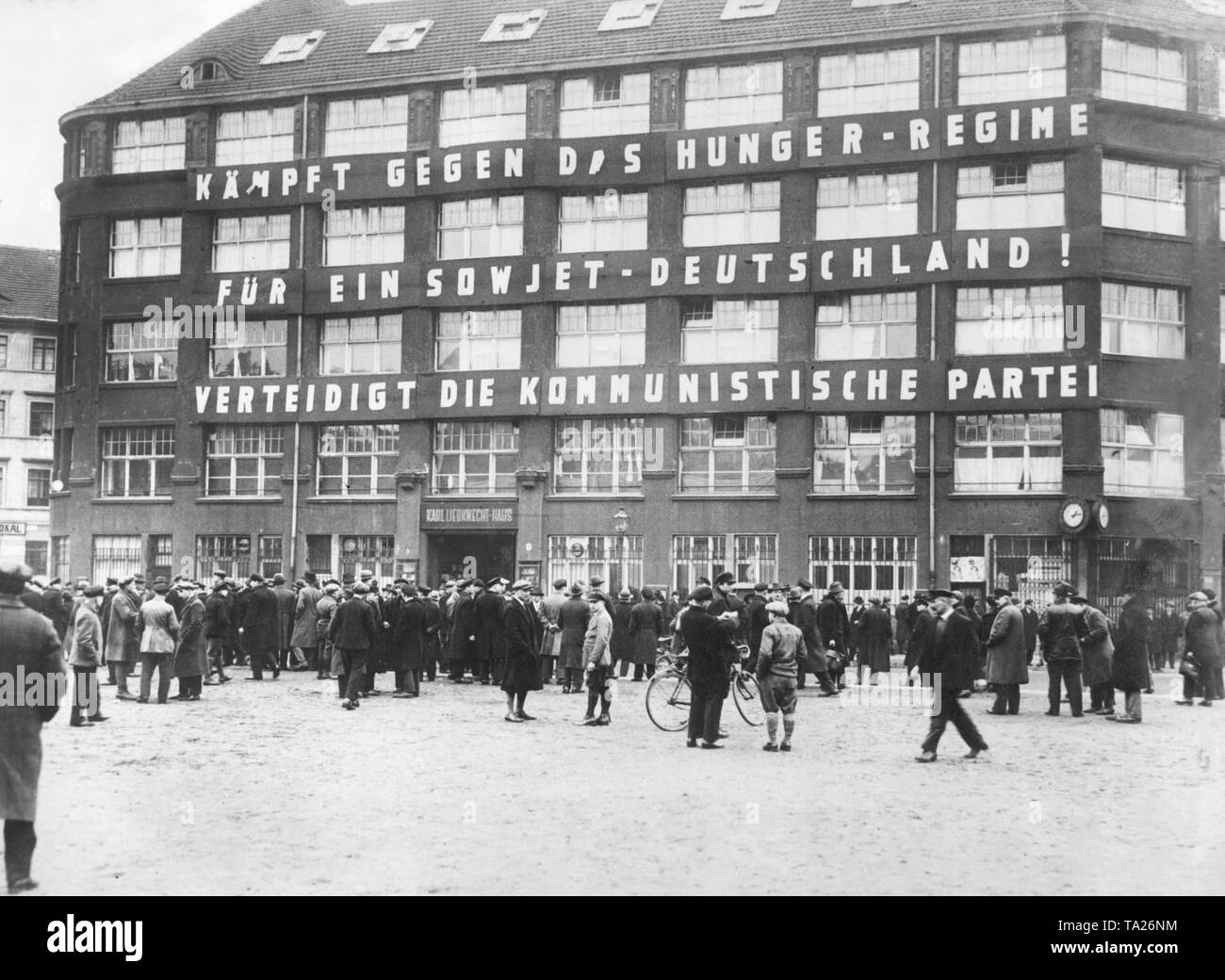Eine Menschenmenge sammelt sich vor dem Hauptquartier der kommunistischen Partei und der Redaktion der 'Die Rote Fahne', das Karl-Liebknecht-Haus an der Buelowplatz in Berlin. Auf dem Haus befindet sich die Aufschrift "gegen Den hunger Regelung für einen sowjetischen Deutschland kämpfen! Die Kommunistische Partei verteidigen. Stockfoto