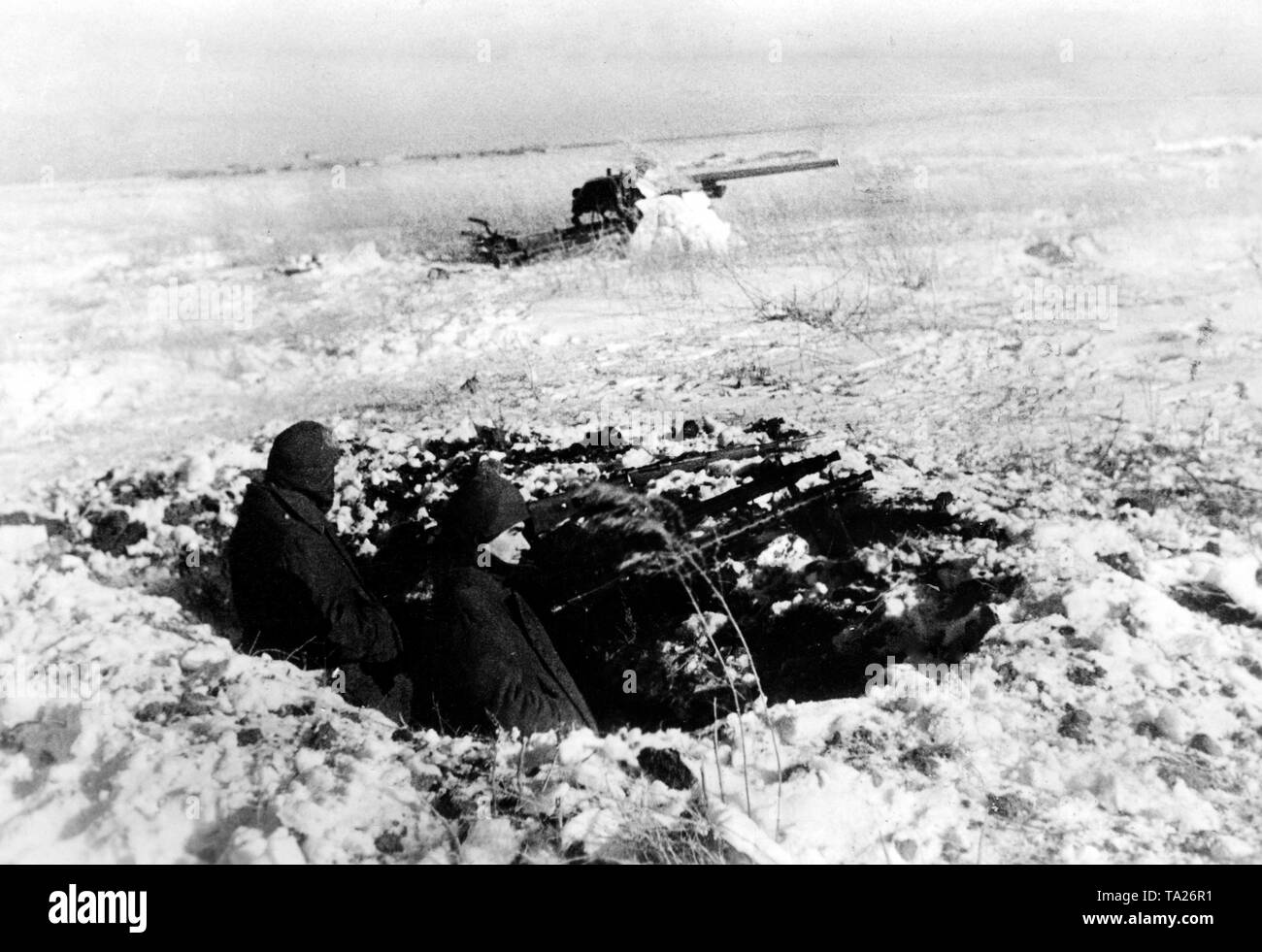 Zwei Soldaten mit einem Maschinengewehr 34 ein Gewehr 98 (Mauser Modell 98) sichern eine 7,5 cm Flak aus einer Schlacht. Foto der Propaganda Firma (PK): kriegsberichterstatter Schoedel. Stockfoto