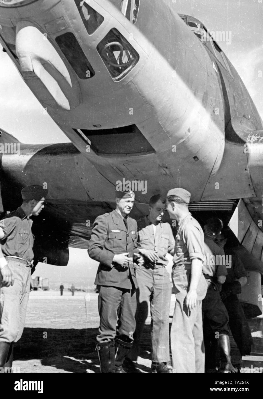 Foto von einem Major der Bekämpfung der Gruppe 88 der Legion Condor im Gespräch mit Soldaten des Bodenpersonals auf einem Flugplatz in Spanien. Die Soldaten stehen unter dem Rumpf eines Heinkel He 111 Bomber. An der oberen Kante des Fotos, das vorwärts gunner Fach, das aus Plexiglas gemacht wurde. Stockfoto