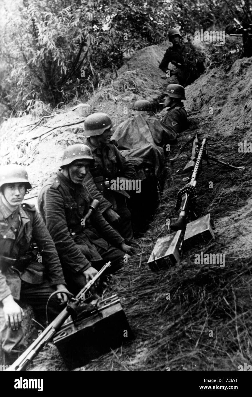 Deutsche Soldaten in einem Graben, während einer Pause in den Kämpfen. Vor Ihnen, mehrere Gewehre und ein Maschinengewehr 34 auf der Hand. Foto der Propaganda Firma (PK): kriegsberichterstatter Lachmann. Stockfoto