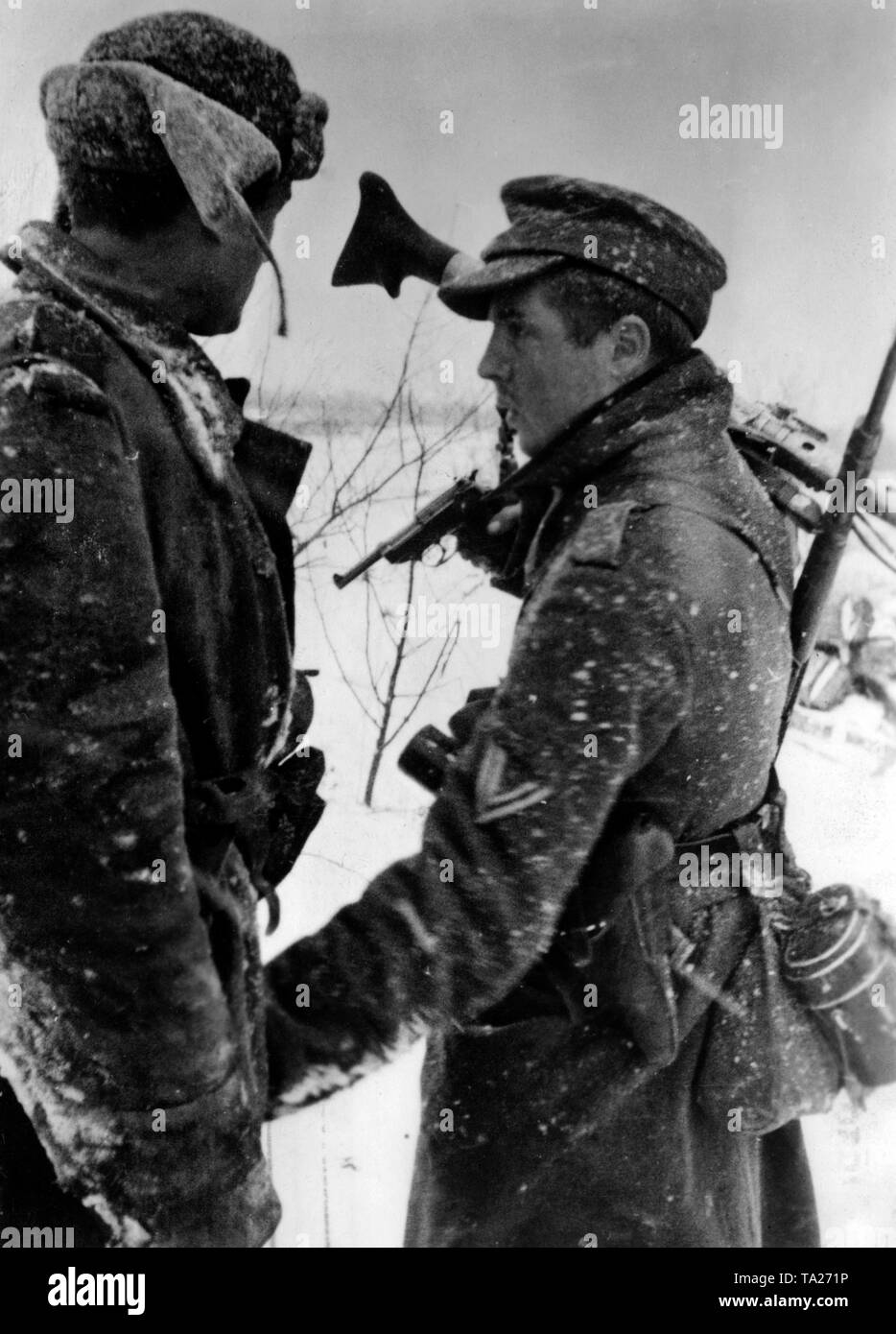 Zwei deutsche Soldaten sprechen auf schneebedeckten Ostfront. Abgesehen von seiner Pistole Walther (S. 38), eine von ihnen trägt ein MG 34 auf seiner Schulter. Foto der Propaganda Firma (PK): kriegsberichterstatter Bergmann. Stockfoto