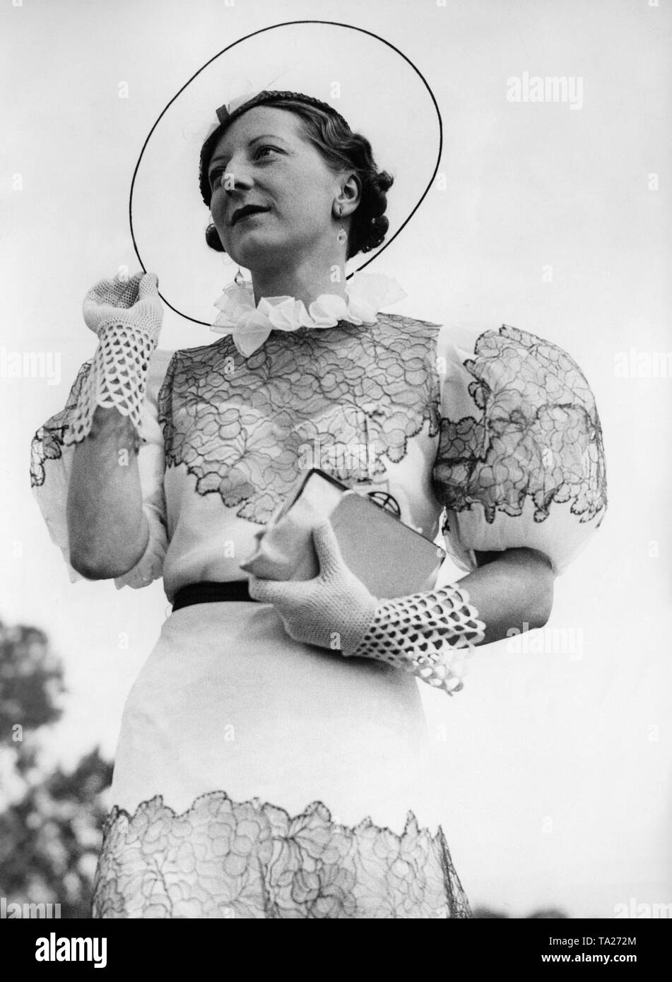 Miss Joyce Pettit trägt eine transparente Zellophan Hut, weißen Kleid mit blauem Netting und puffärmel an der Henley Regatta" in Oxfordshire. Stockfoto