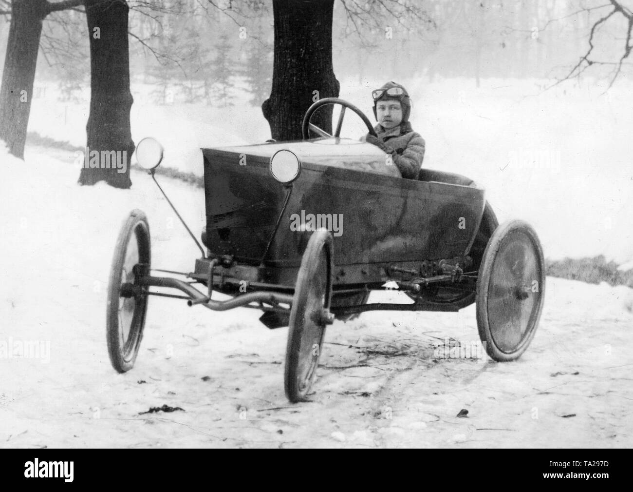 Ferry Porsche, Sohn von Professor Ferdinand Porsche, fährt mit seinem ersten Auto, einem Austro-Daimler mit einer Feldbahn Motor. Das Auto wurde nach Plänen von Ferdinand Porsche, der es an seinen Sohn gab als Weihnachtsgeschenk im Jahr 1921 gebaut. Stockfoto