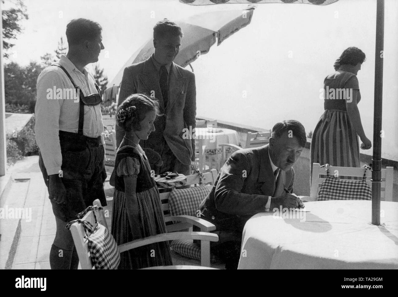 Adolf Hitler gibt ein Mädchen ein auf der Terrasse des Berghof auf dem Obersalzberg Autogramm. Stockfoto