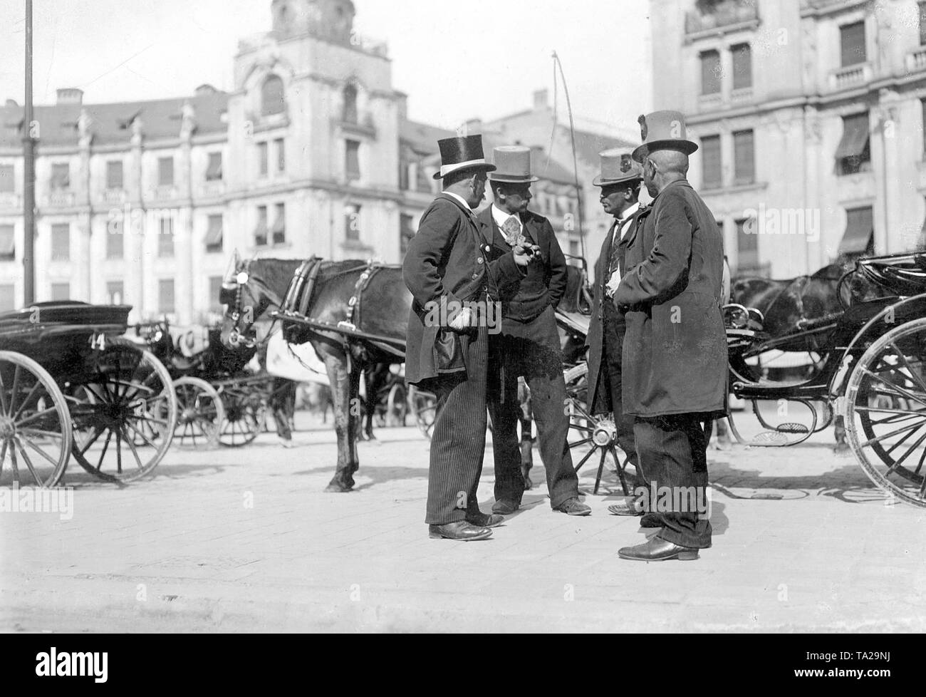 Kutscher sprechen vor ihre Kabinen auf dem Karlsplatz Stachus im Zentrum von München. Das Foto wurde im frühen 20. Jahrhundert genommen (vor 1914). Stockfoto