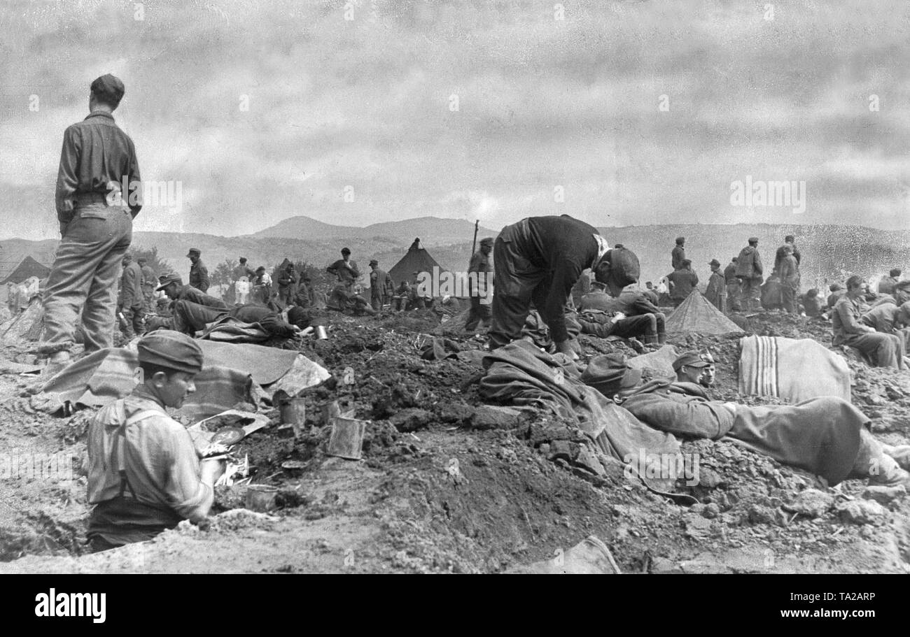 Deutsche Soldaten in einem provisorischen Lager in Remagen. Die Gefangenen haben keinen Schutz gegen das Wetter, nur Löcher im Boden und Decken. Stockfoto
