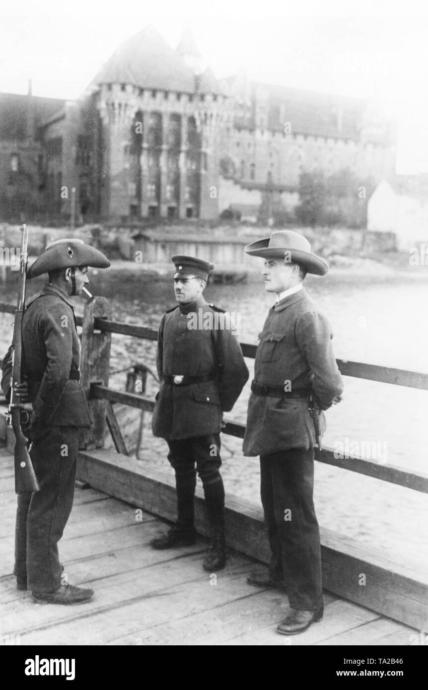 Danzig Grenzschutzbeamten (mit dem Rücken zum Betrachter und rechts nach links) zur polizeilichen Dienst gemeinsam mit deutschen Sicherheit Polizist (links) in der Volksabstimmung, die Fläche, die von Deutschland nach dem Ersten Weltkrieg getrennt wurde, hier auf die konkrete Brücke an der Marienburg. Stockfoto