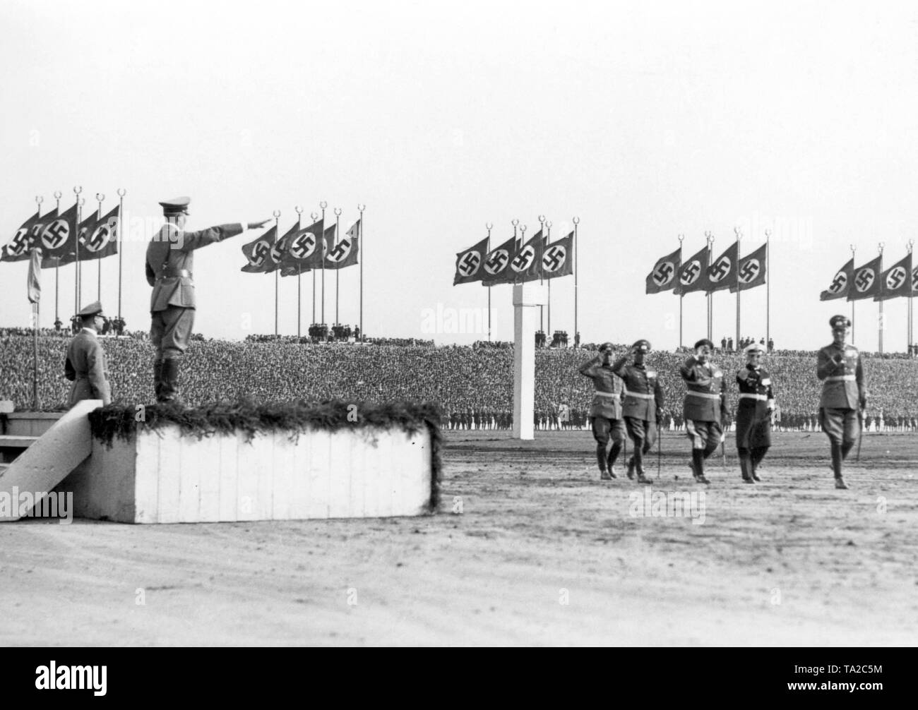 Adolf Hitler, in der Tribüne stehen, begrüßt die marschierenden Oberkommandierenden der Streitkräfte. Von rechts: Werner von Blomberg, Erich Raeder, Hermann Göring, Werner von Fritsch. Auf Hitlers links Rudolf Hess. Stockfoto