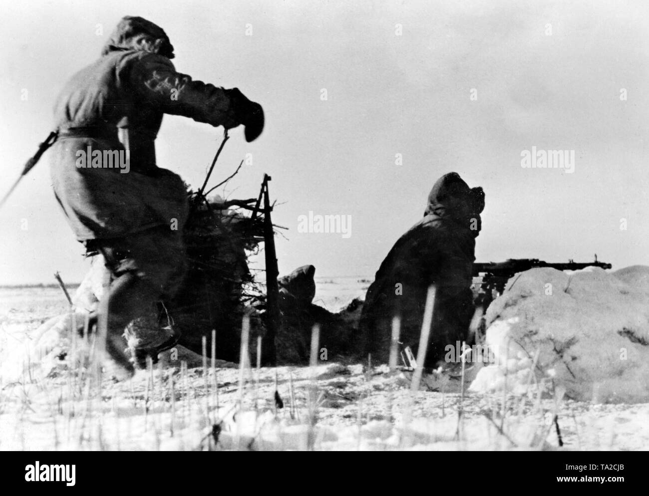 Während ein Soldat bereits auf der Maschine Gewehr sitzend, ein anderes kommt man in den Kämpfen Position laufen. Foto der Propaganda Firma (PK): kriegsberichterstatter Tufts. Stockfoto