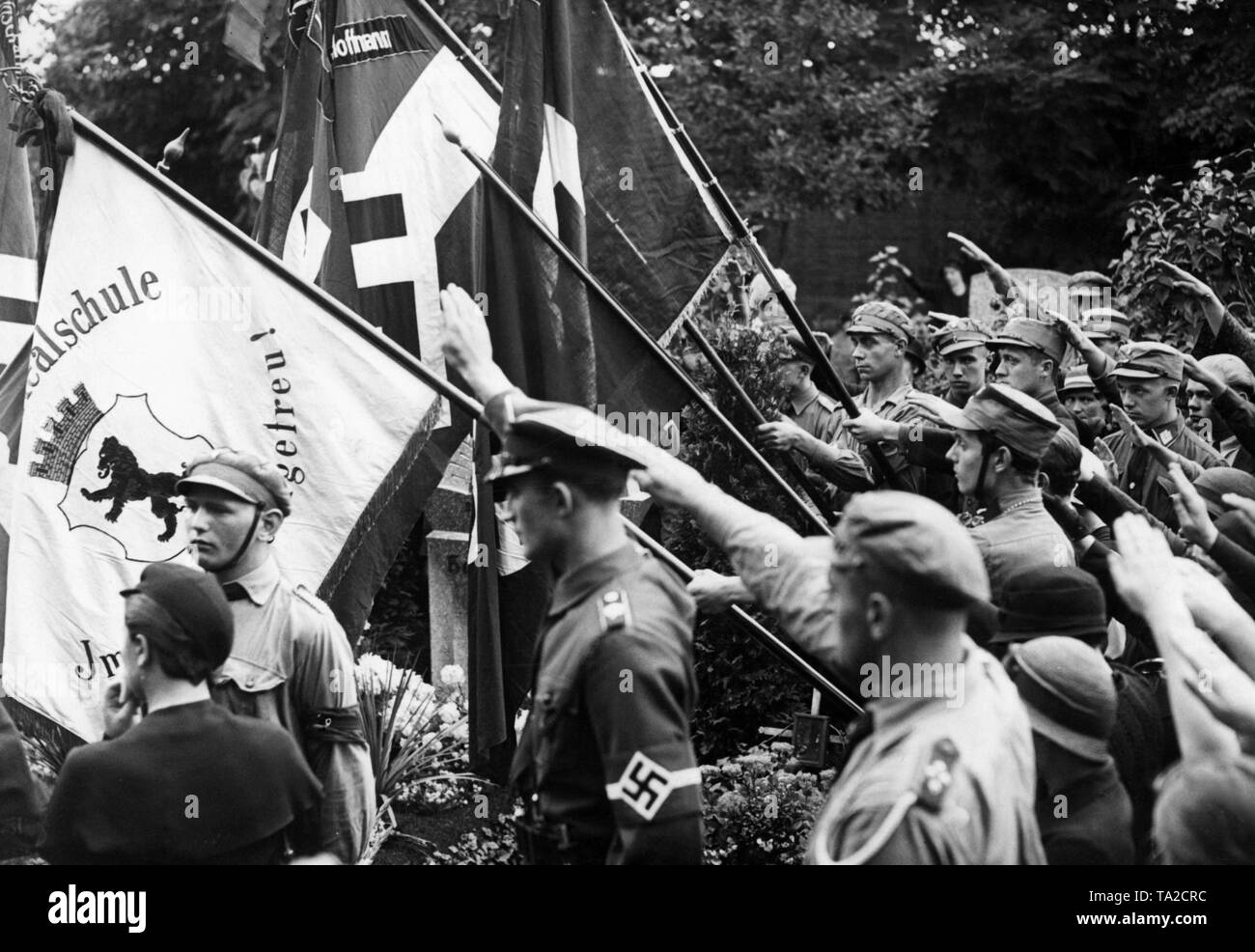 Im Alter Garnisonfriedhof Hasenheide am Columbiadamm in Berlin-neukölln, ein Gedenkstein an die Hitlerjunge Hans Hoffmann, der am Lausitzer Platz in Kreuzberg am 17. August getötet wurde, geweiht. Neben den Flaggen der Hitler Jugend, es gibt auch eine Fahne von einem Berliner Gymnasium. Stockfoto