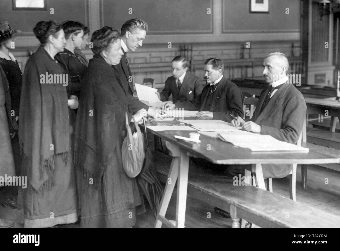 Wahllokal in Berlin, in denen zahlreiche Frauen als Wählerinnen in den Abstimmungslisten registriert sind. Zum ersten Mal in der deutschen Geschichte, hatten Frauen das volle aktive und passive Wahlrecht recht, hier bei den Wahlen zur Nationalversammlung am 19.1.1919. Stockfoto