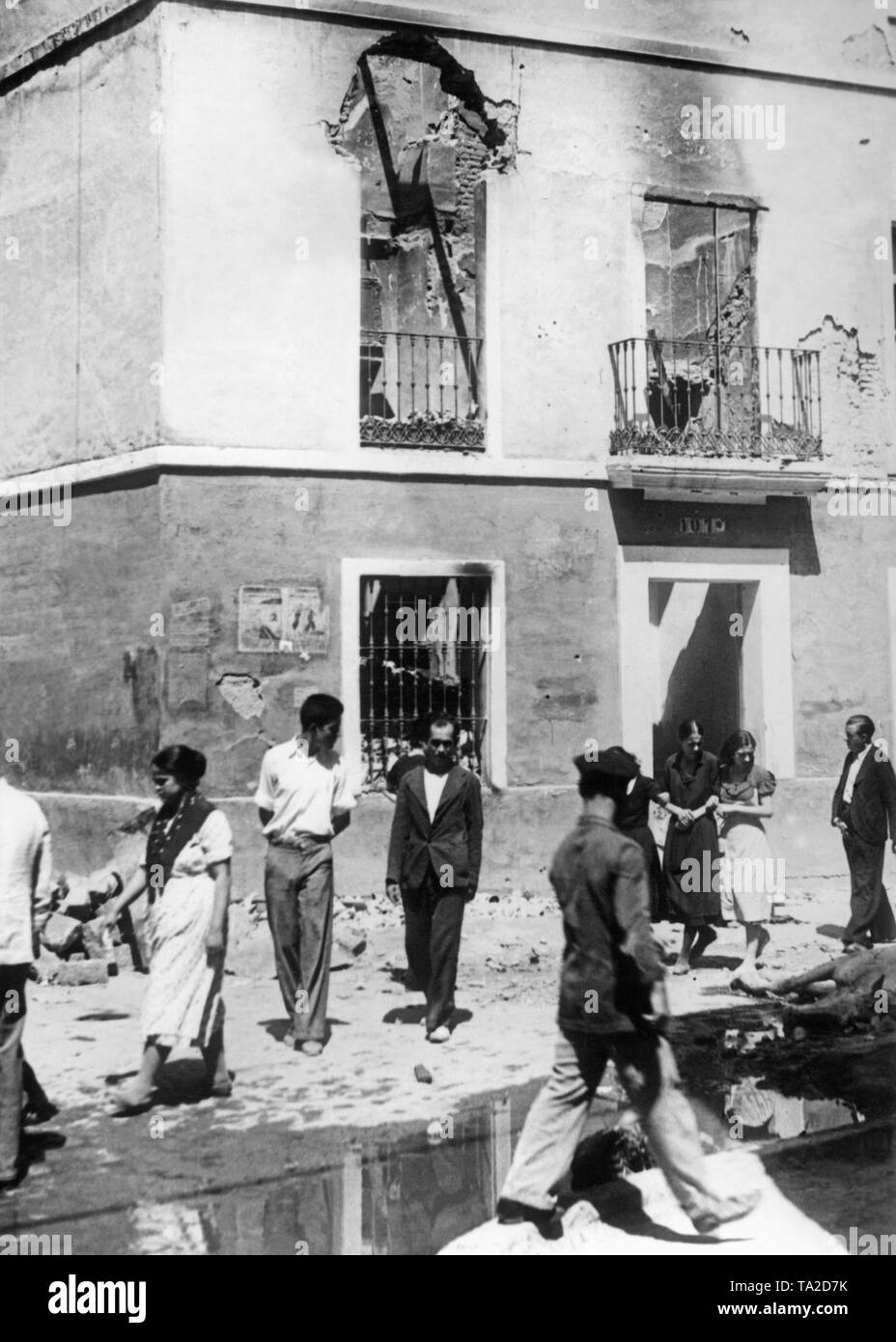 Foto eines teilweise zerstört Wohnhaus in Sevilla im Sommer 1936. Im Vordergrund, Passanten. Stockfoto