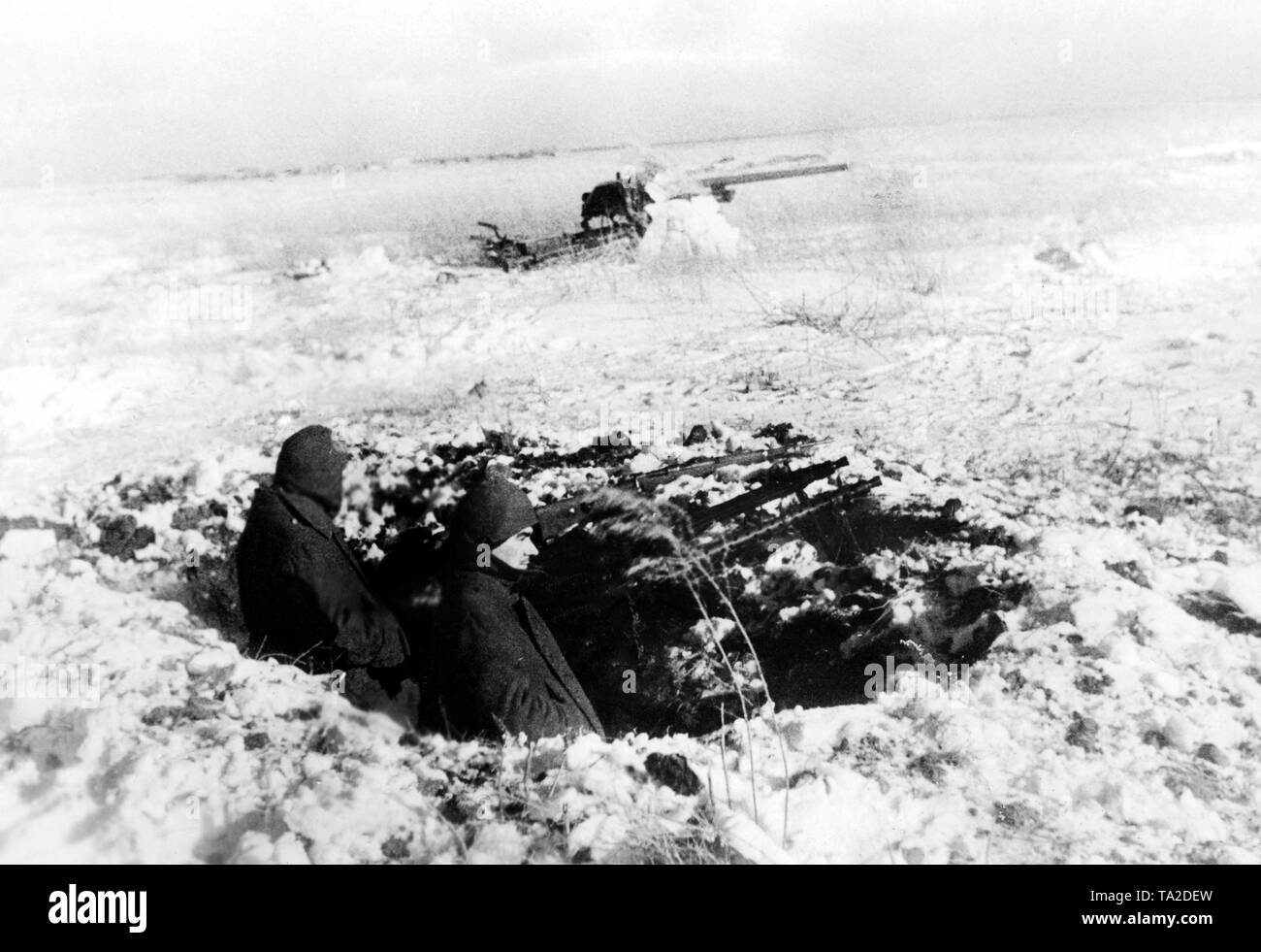 Zwei Soldaten mit MGs 34 ein Gewehr 98 (Mauser Modell 98) sichern eine 7,5 cm Flak aus einer Schlacht. Foto der Propaganda Firma (PK): kriegsberichterstatter Schoedel. Stockfoto